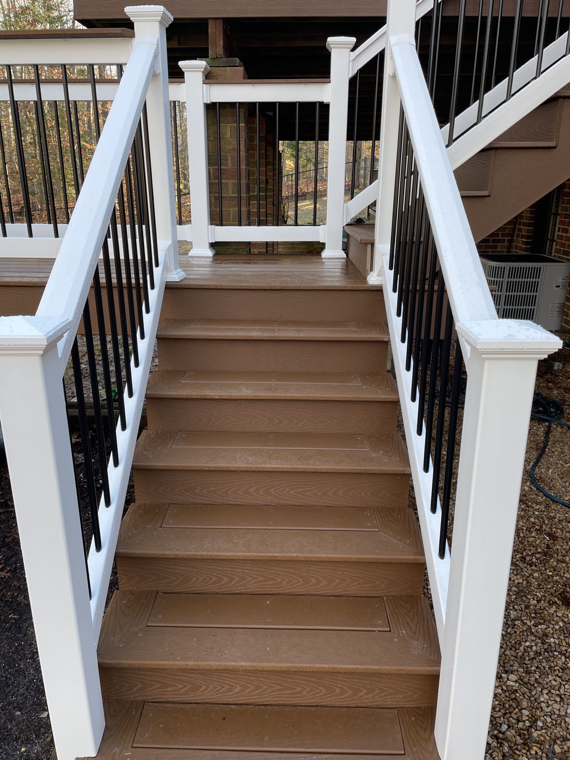A set of stairs leading up to a deck with a white railing.
