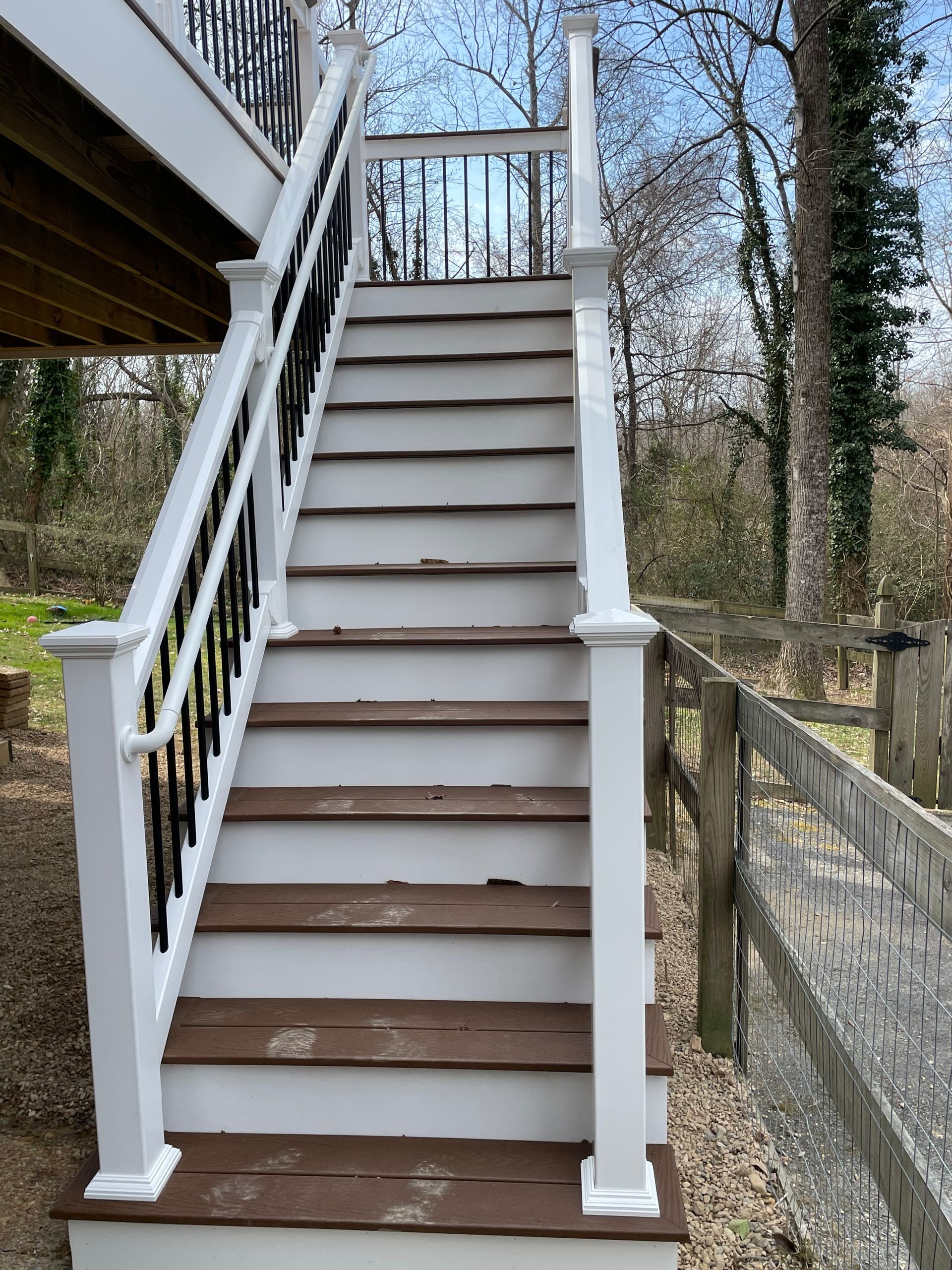 A set of stairs leading up to a deck with a wooden railing.