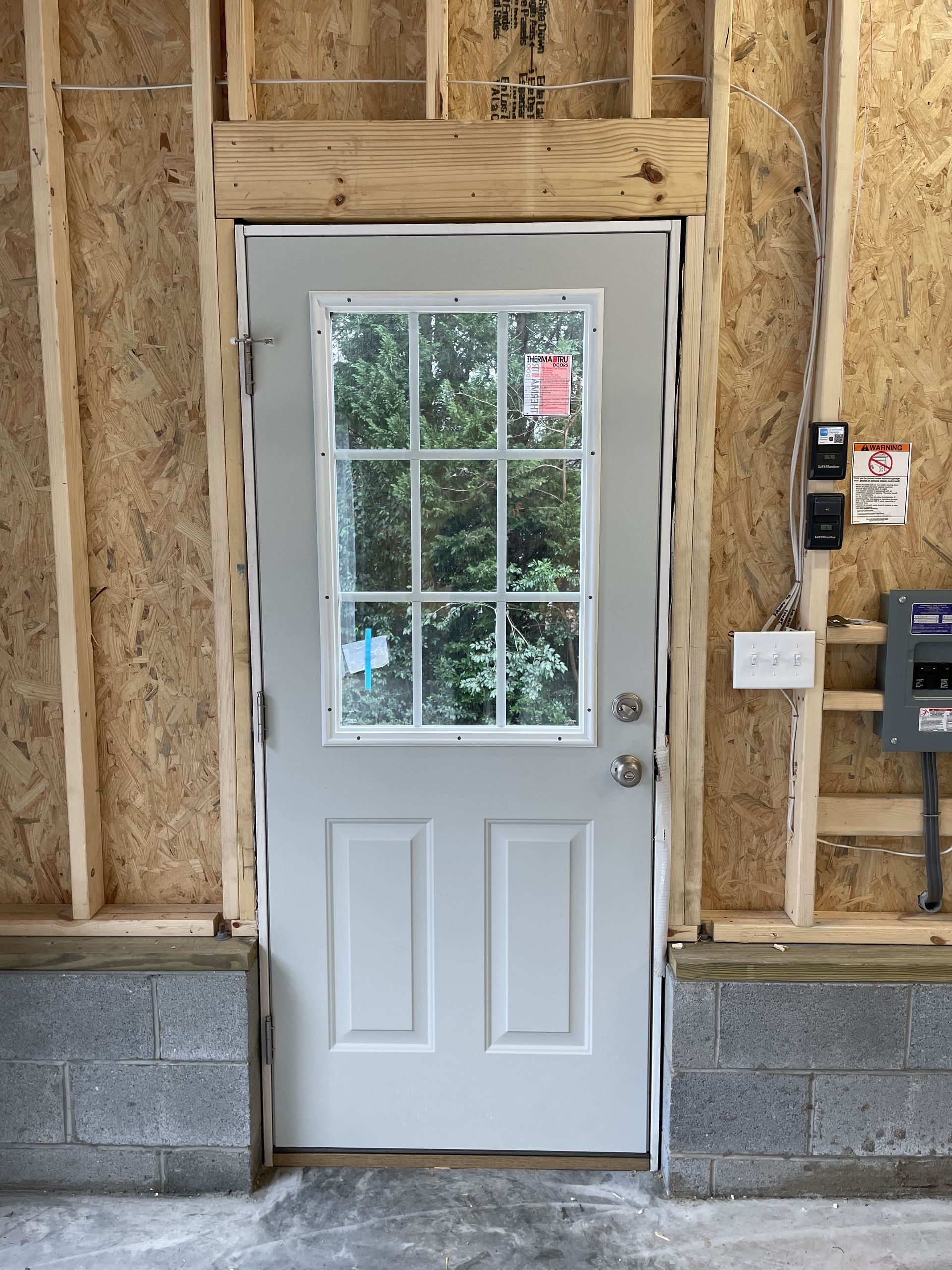 A white door with a window in a building under construction