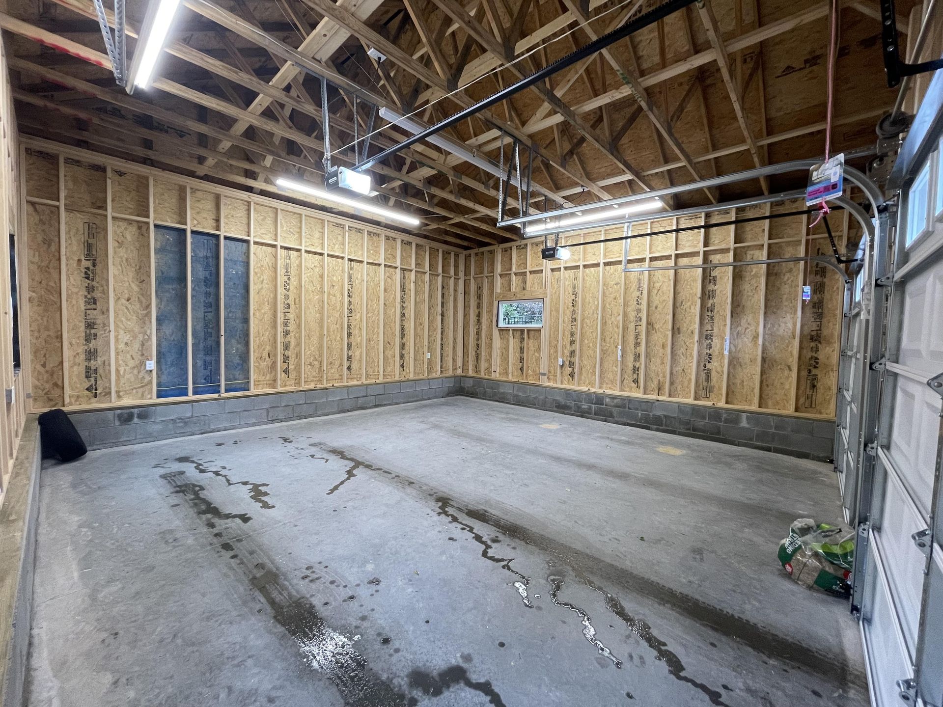 An empty garage with wooden walls and a concrete floor.