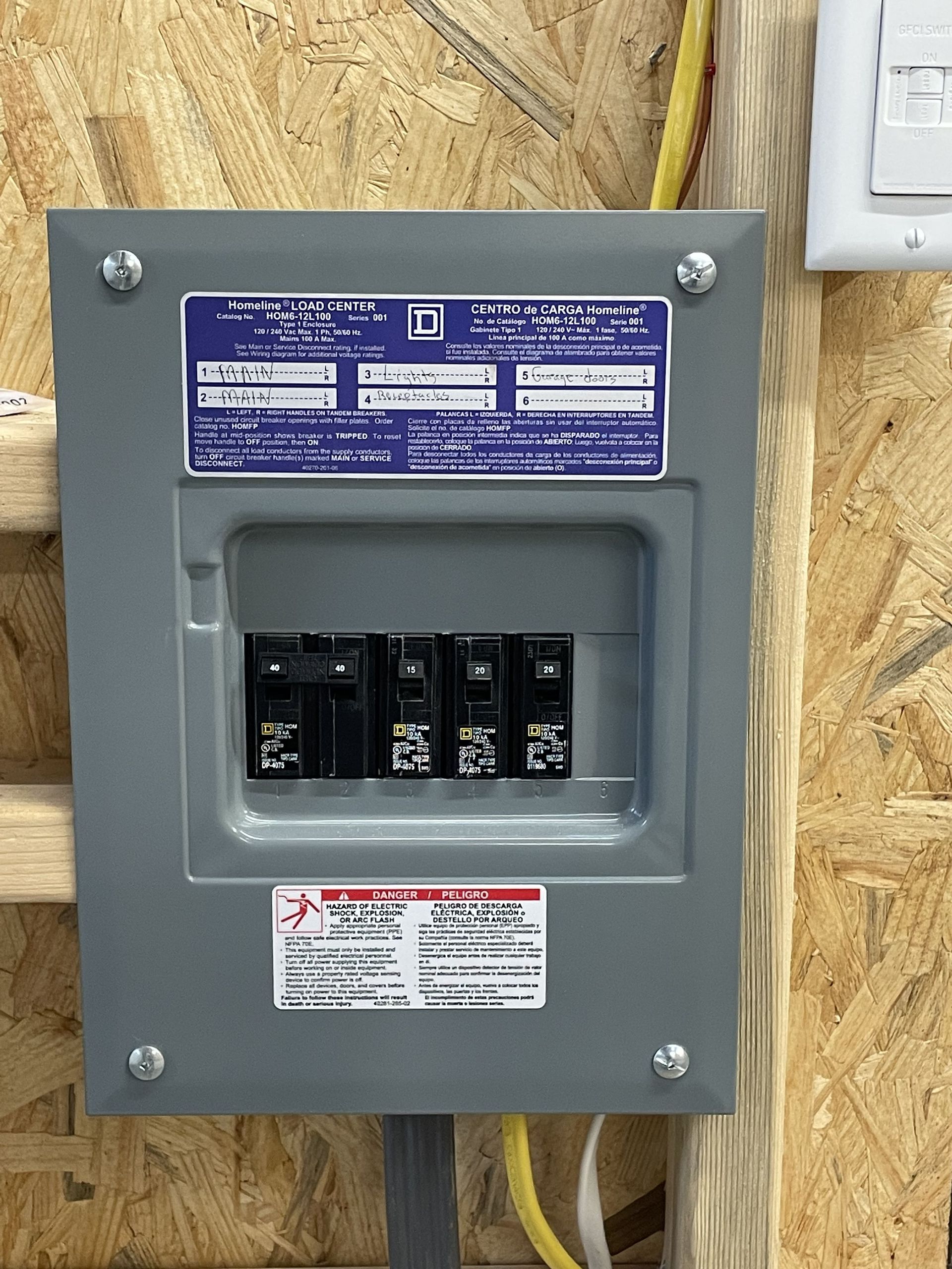 A close up of a electrical box on a wooden wall.