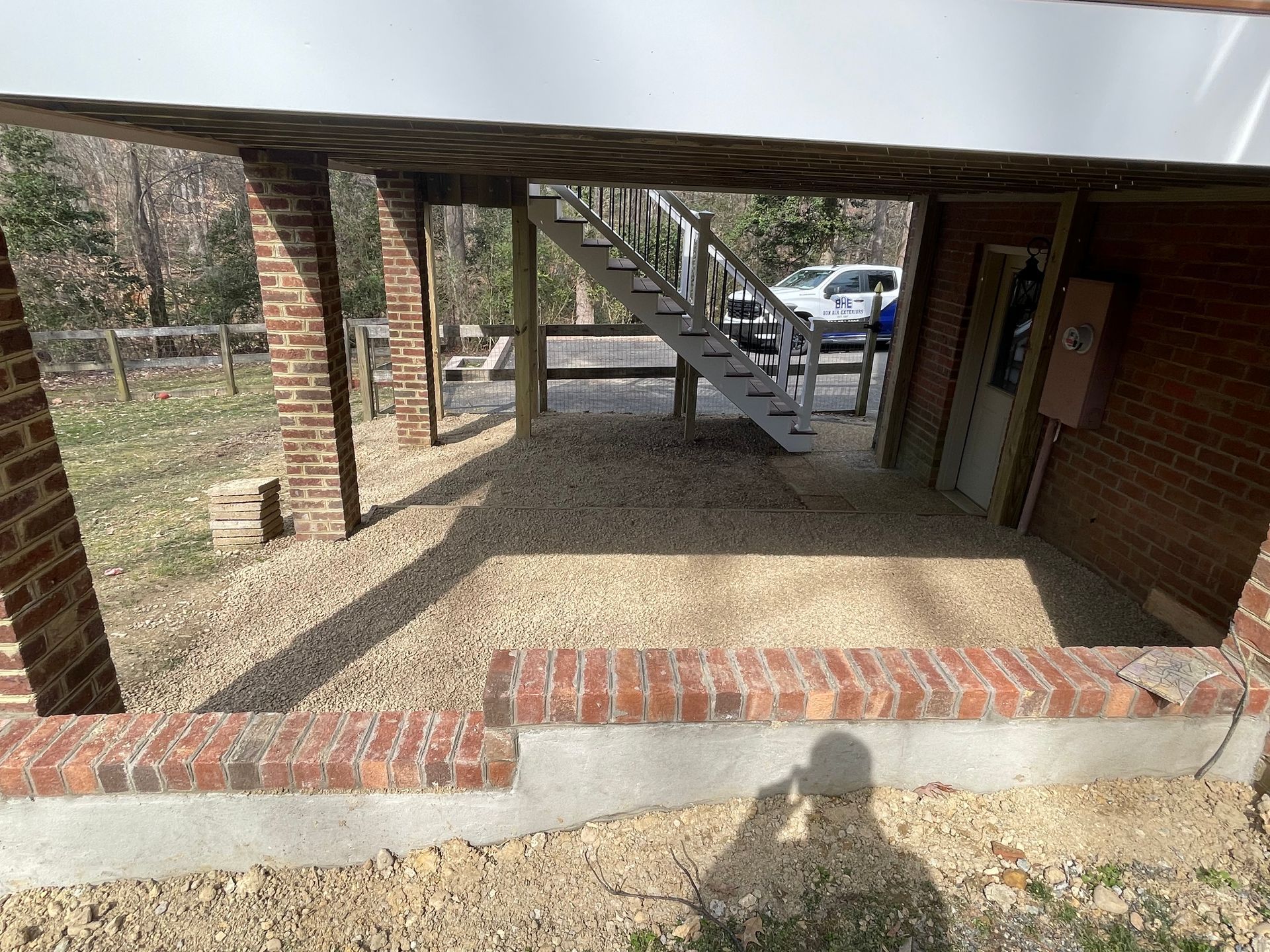 A brick building with stairs leading up to a garage underneath it.