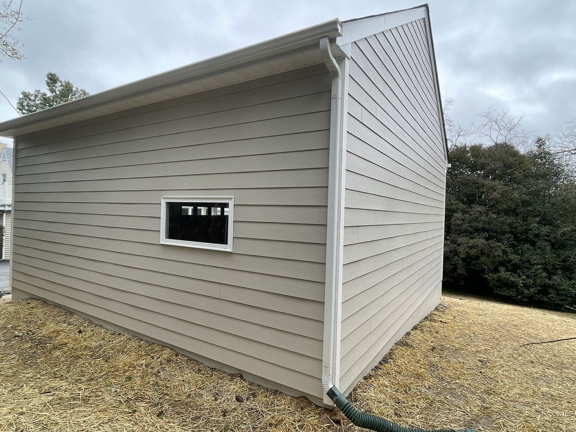 A small white building with a window on the side of it.