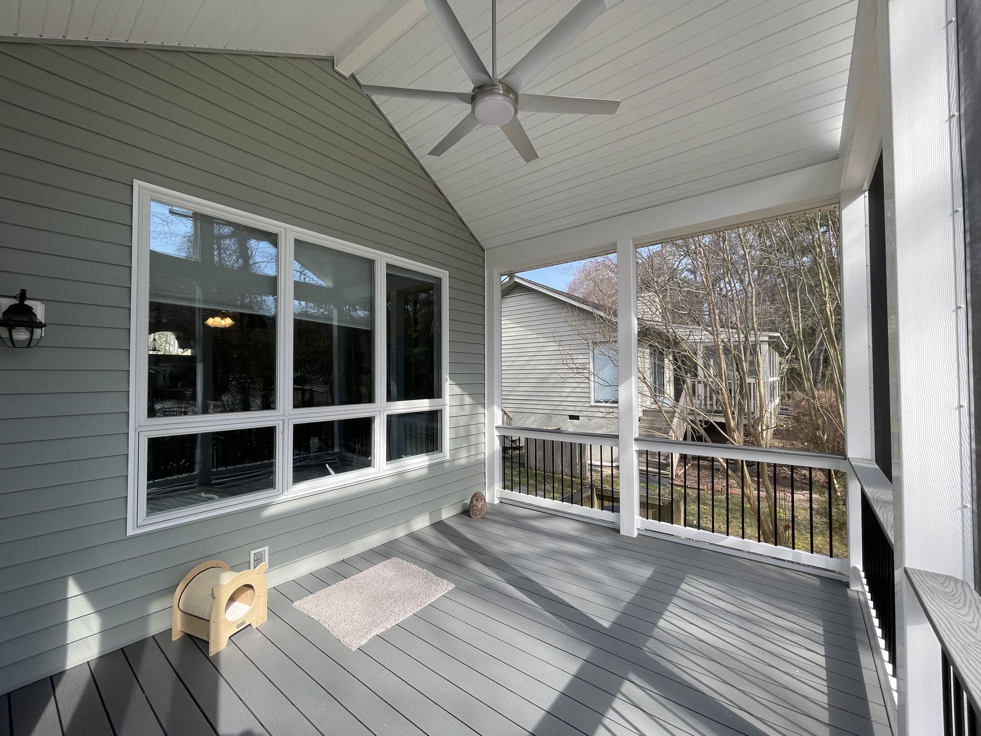 A screened in porch with a ceiling fan