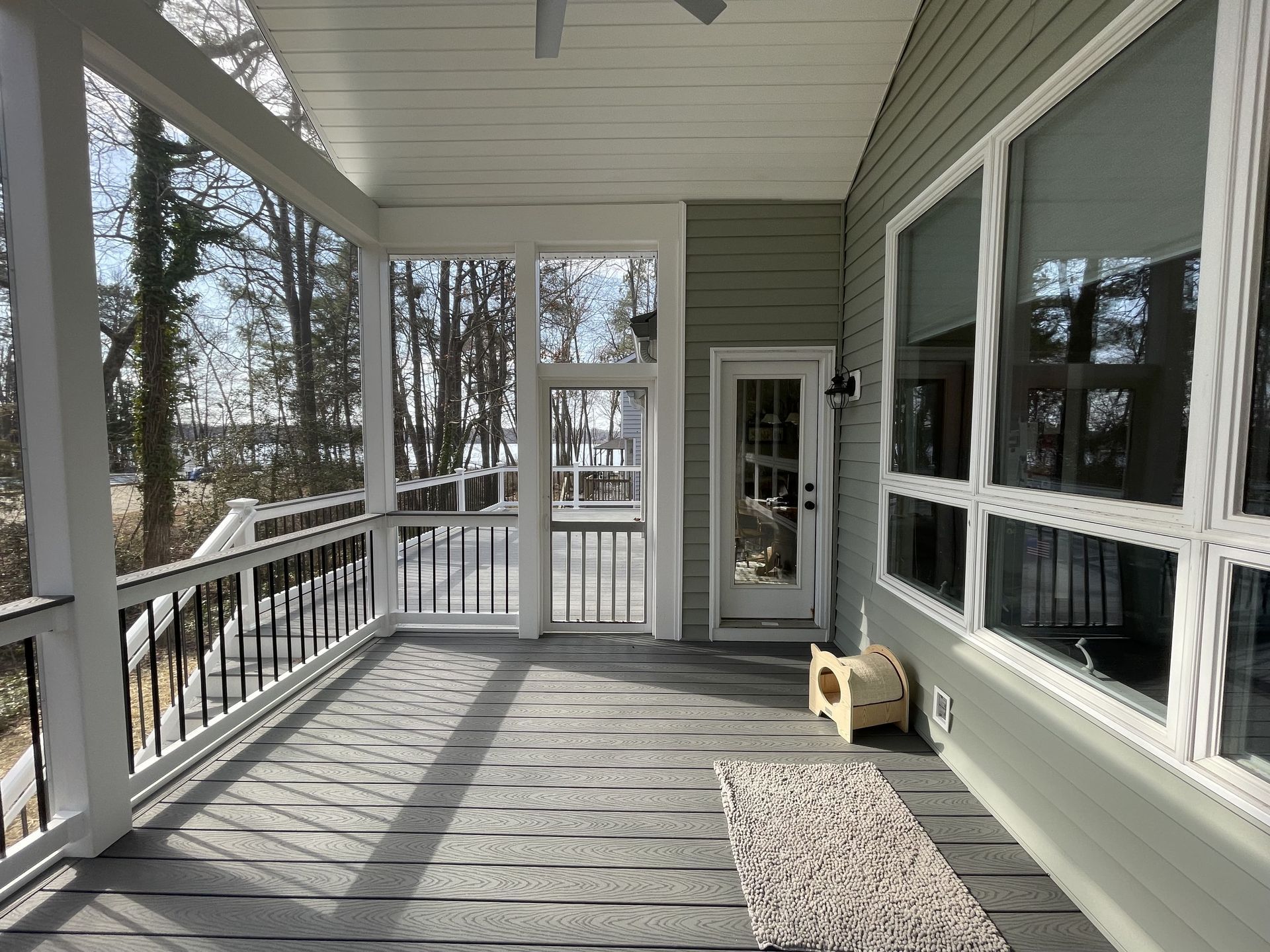 A screened in porch with a door and lots of windows
