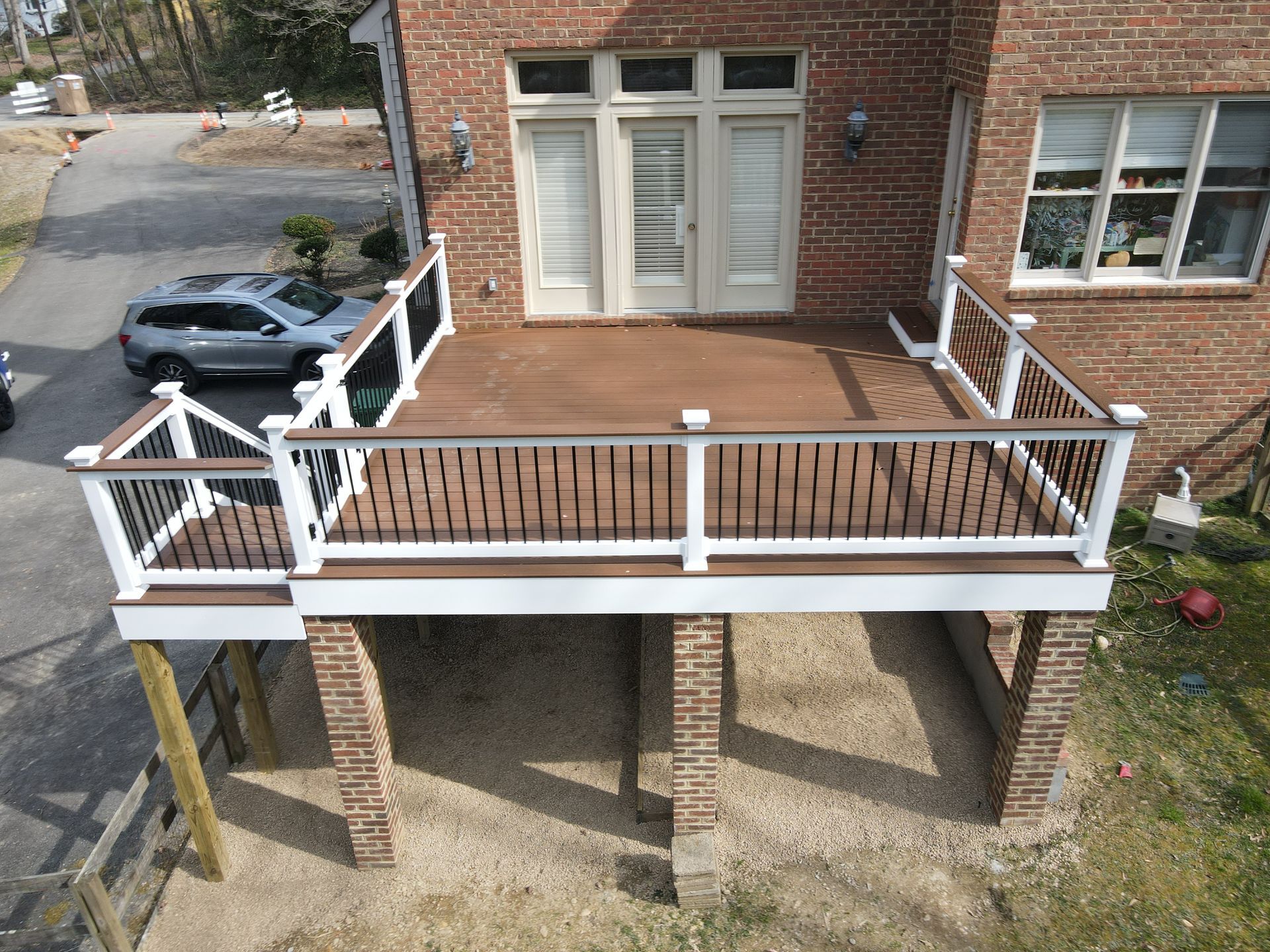 An aerial view of a brick house with a wooden deck