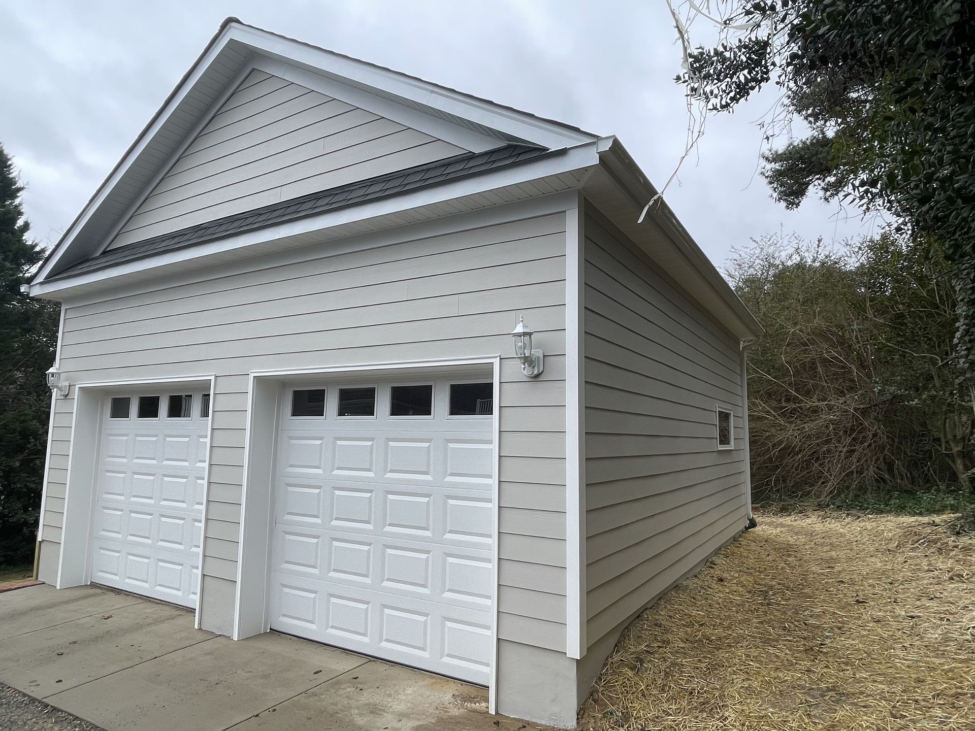 A white garage with two garage doors and a roof
