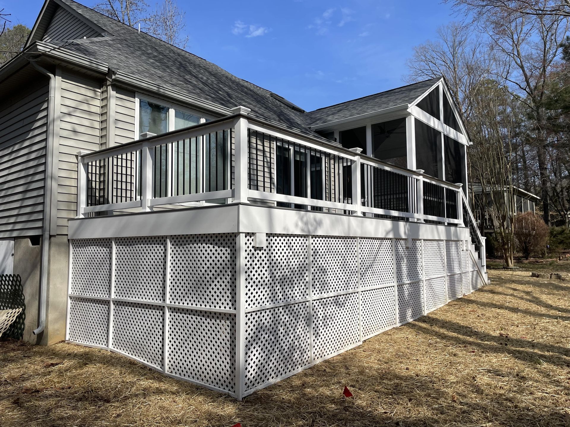 A house with a screened in porch and a large deck.