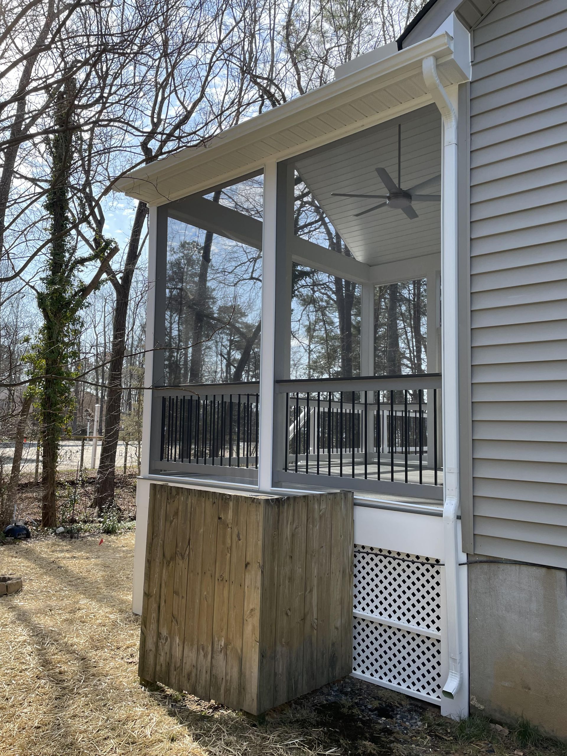 A screened in porch on the side of a house
