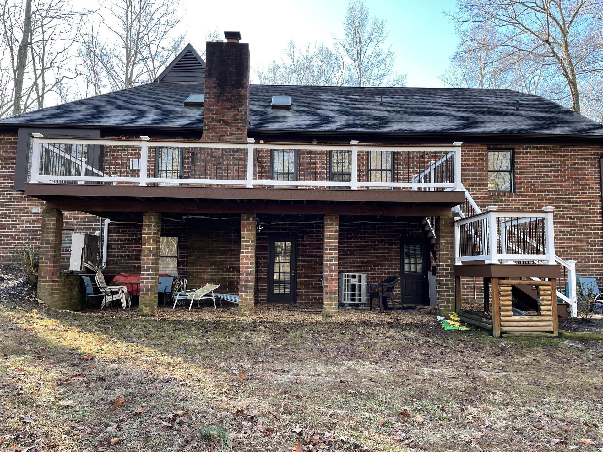 The back of a house with a large deck and a chimney