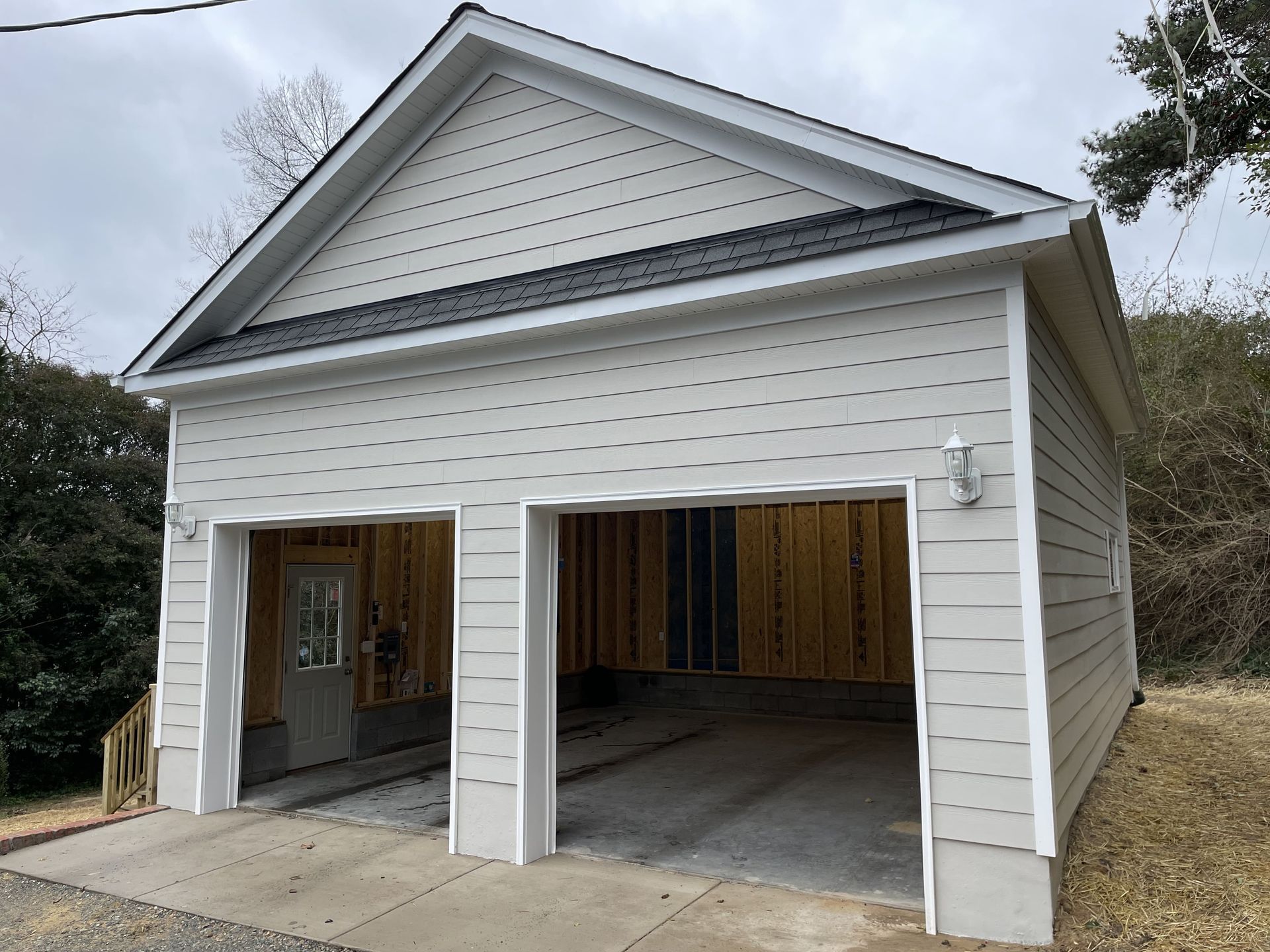 A white garage with two doors is being built.