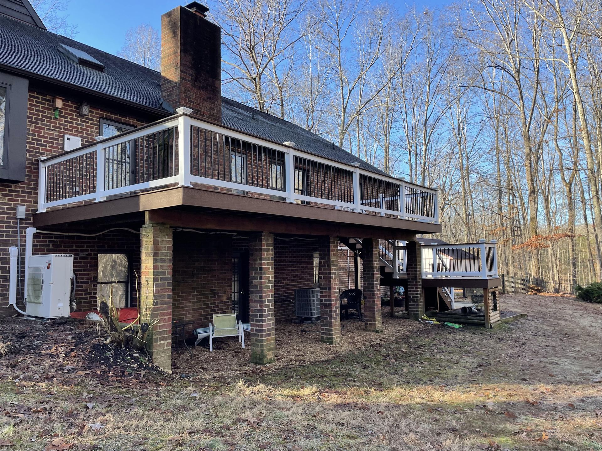 A large brick house with a large deck in the backyard.
