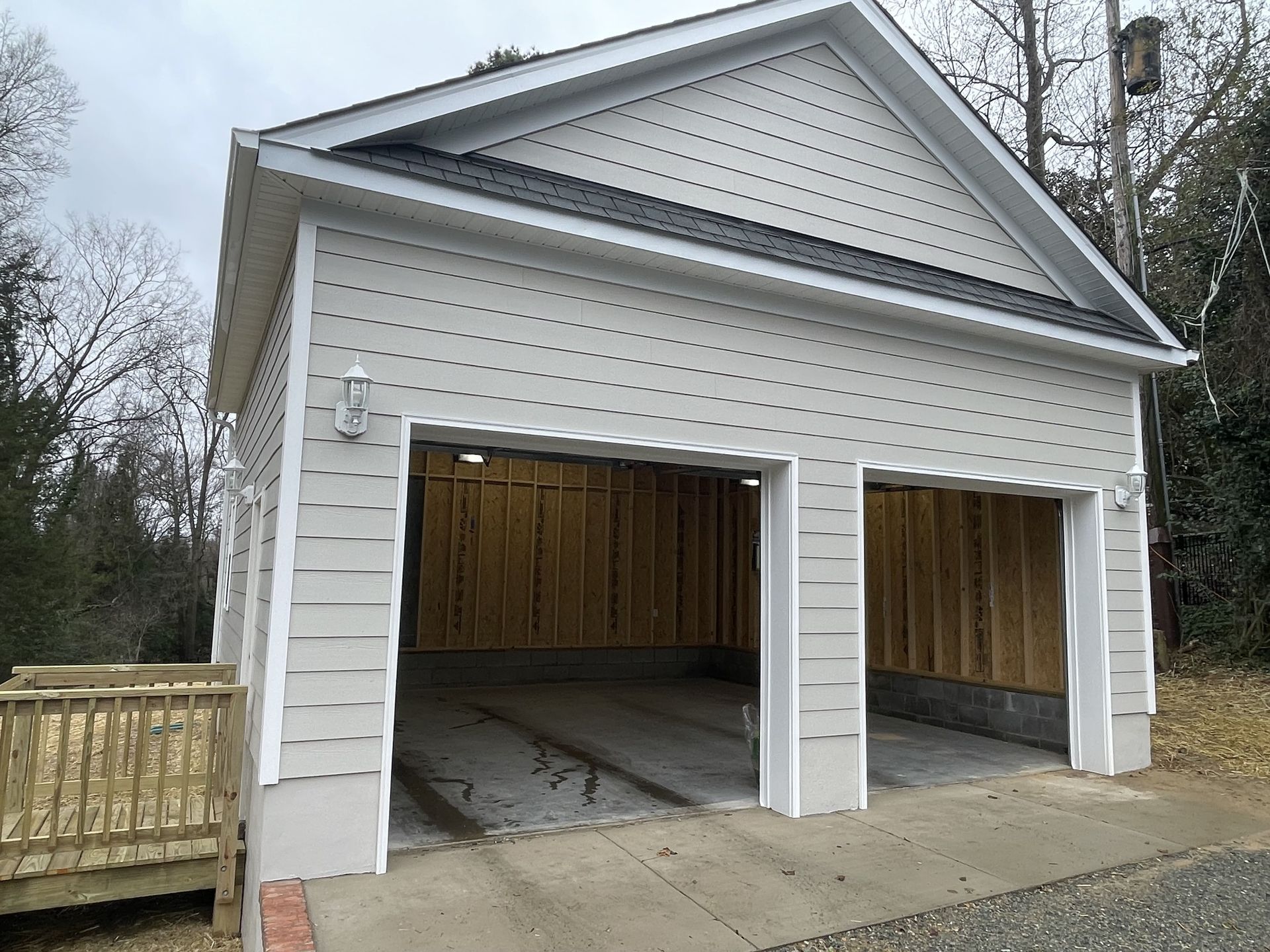 A white garage with two doors is under construction.