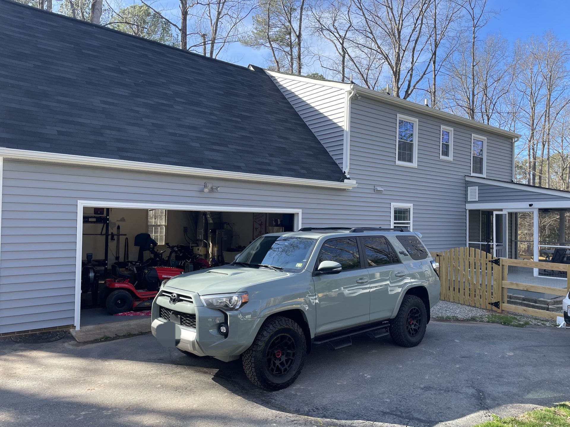 A toyota 4runner is parked in front of a garage.