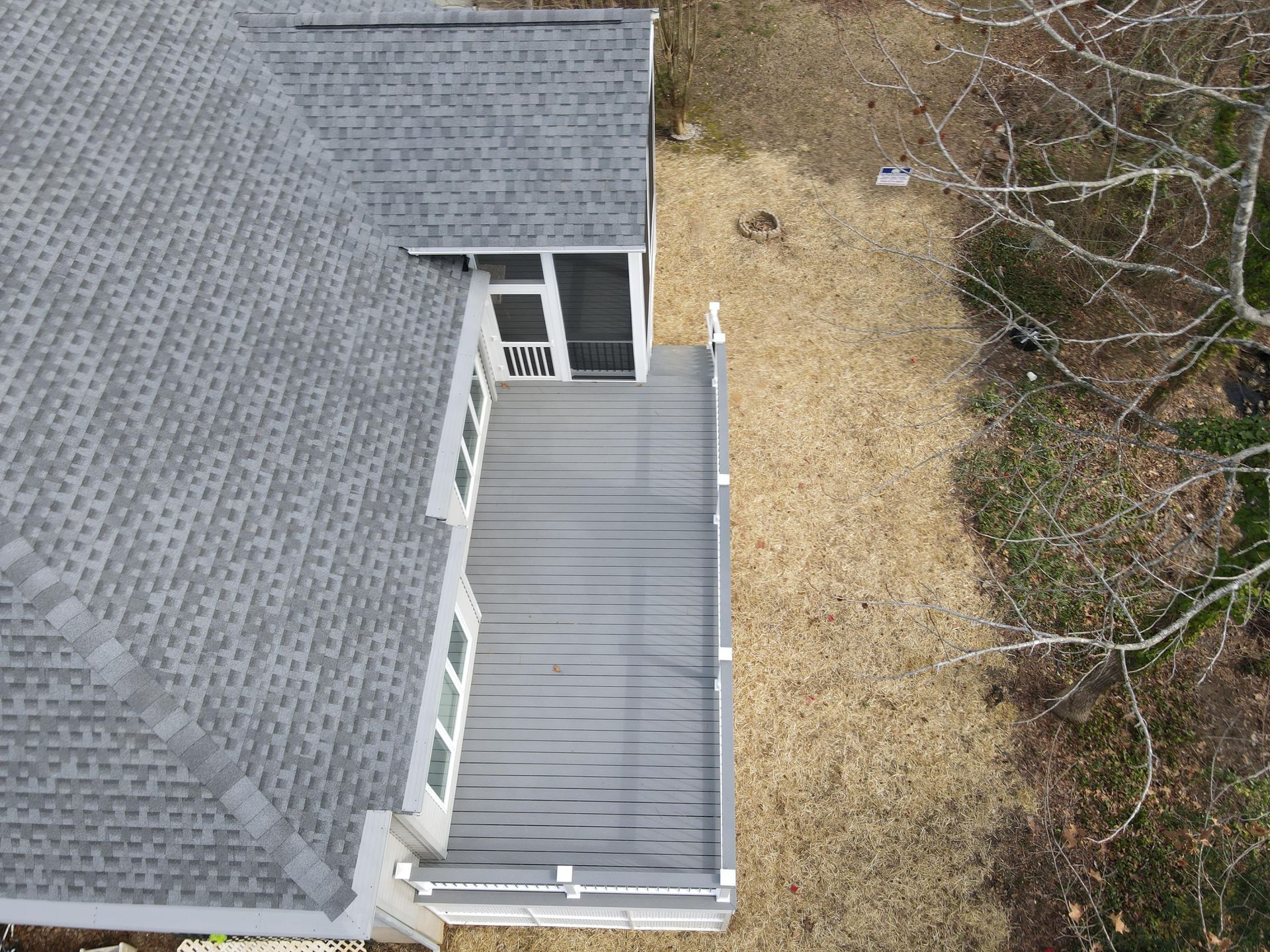 An aerial view of a house with a deck and a screened in porch.