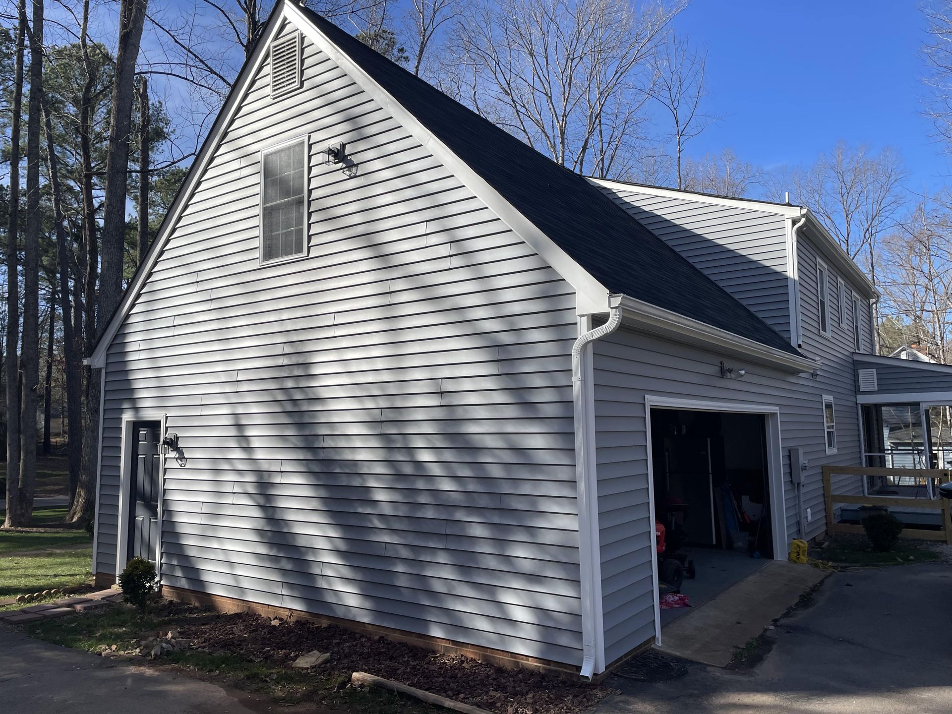 A white house with a black roof and a garage.