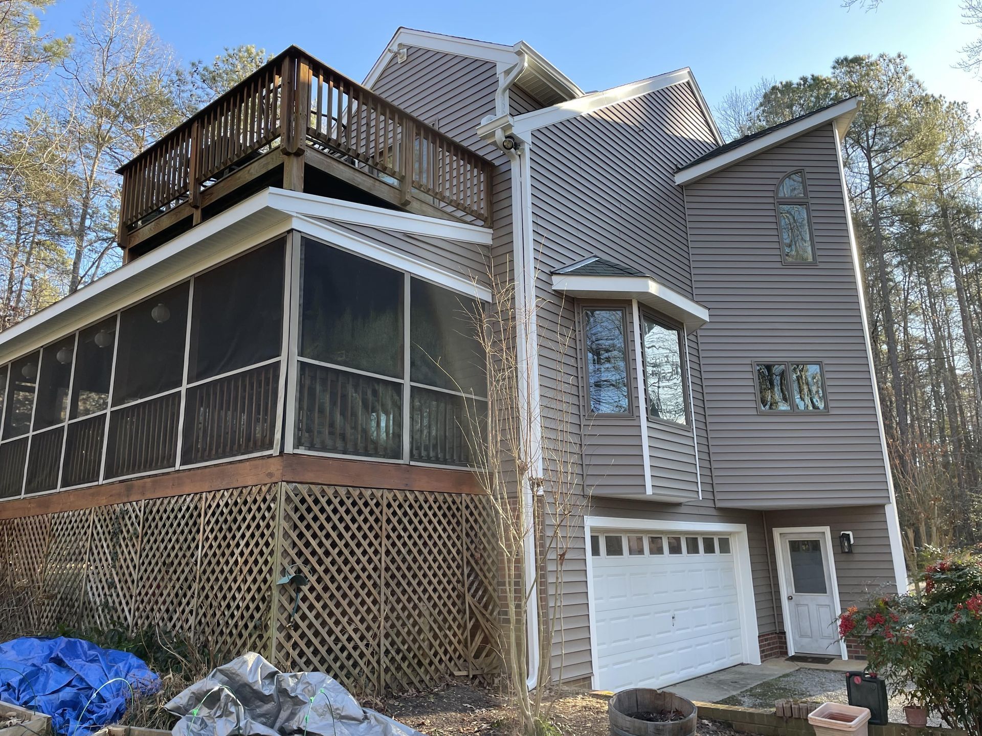 A large house with a screened in porch and a deck.