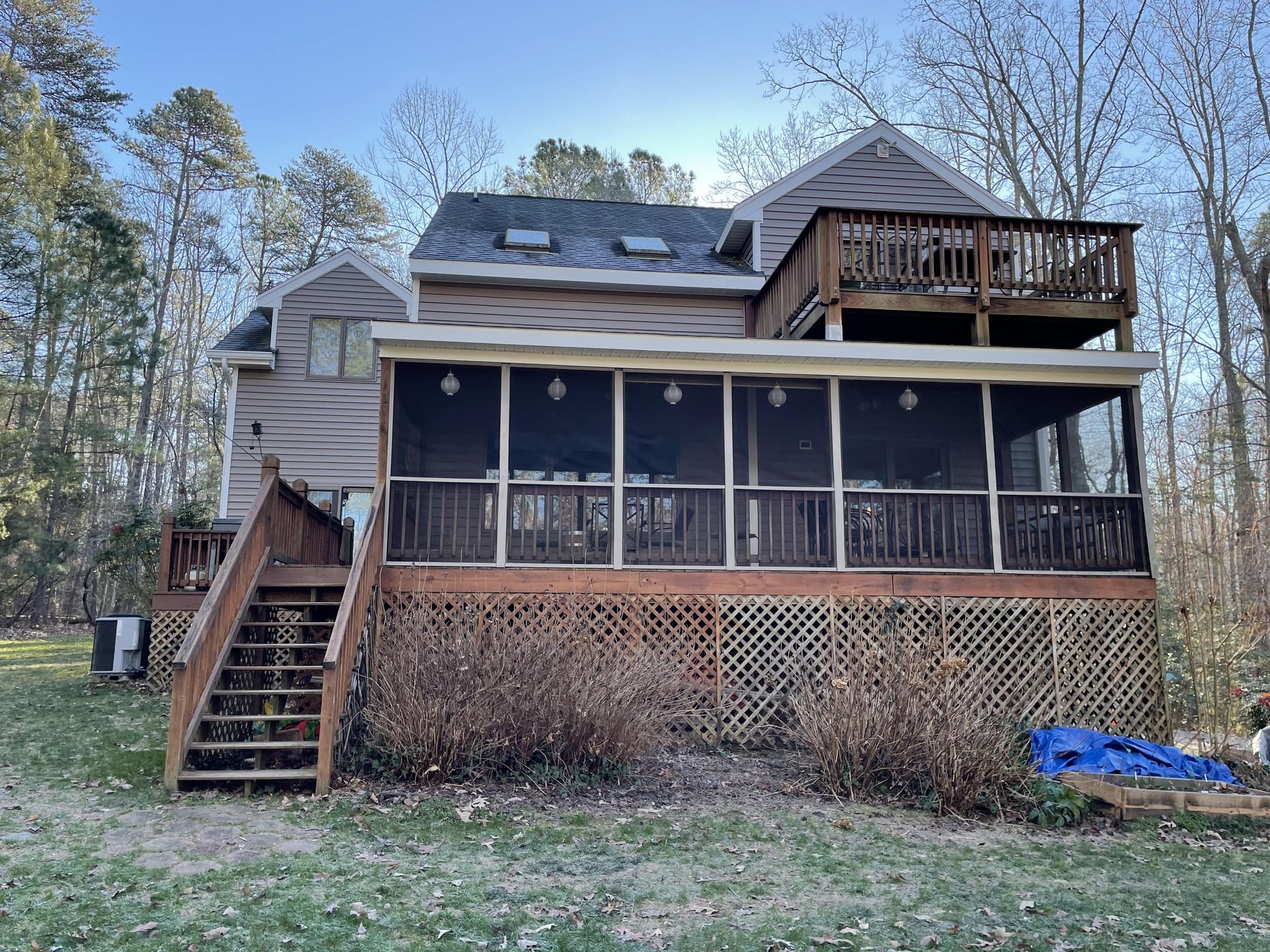 The back of a house with a screened in porch and stairs
