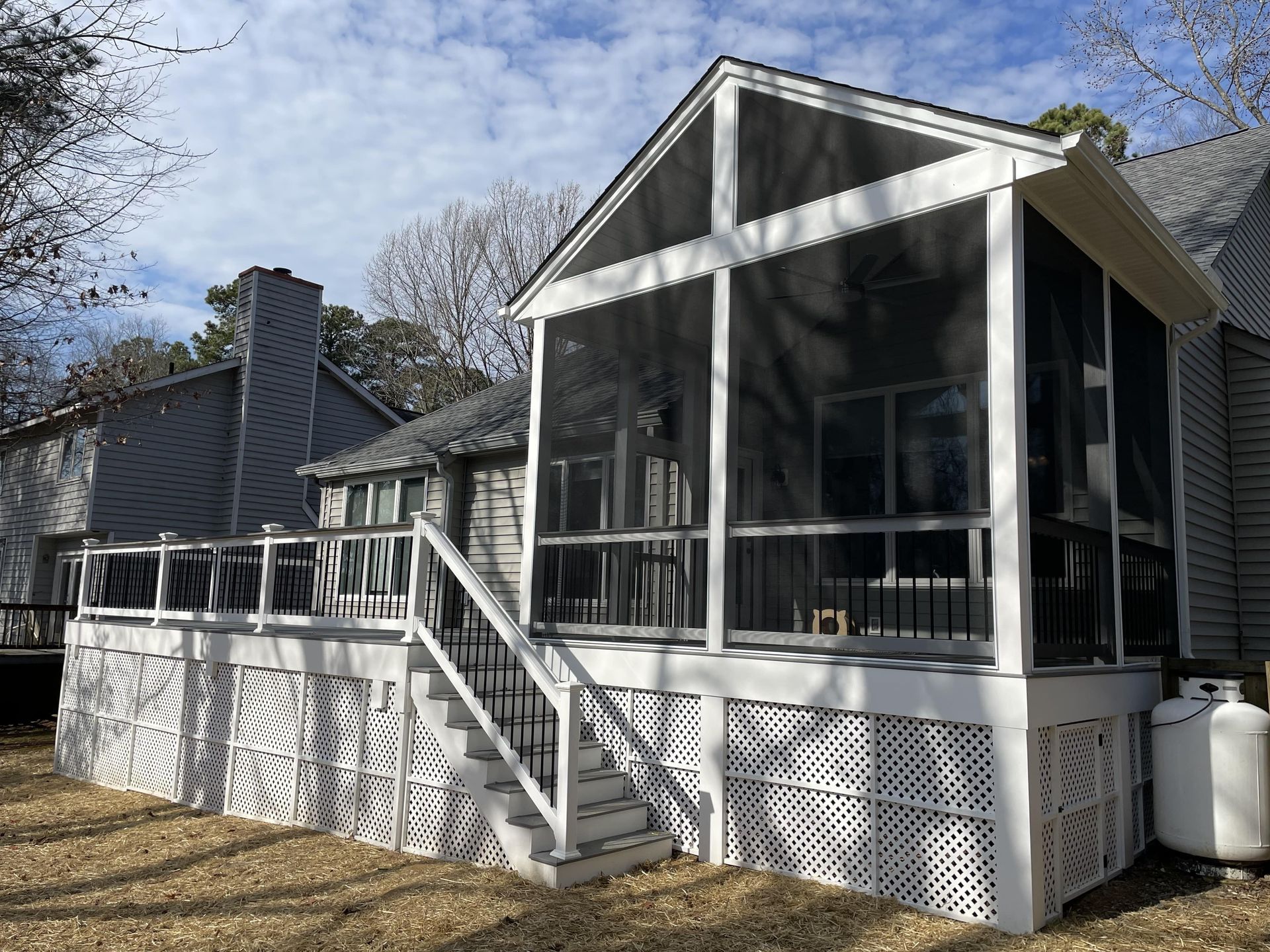 There is a screened in porch with stairs leading up to it.
