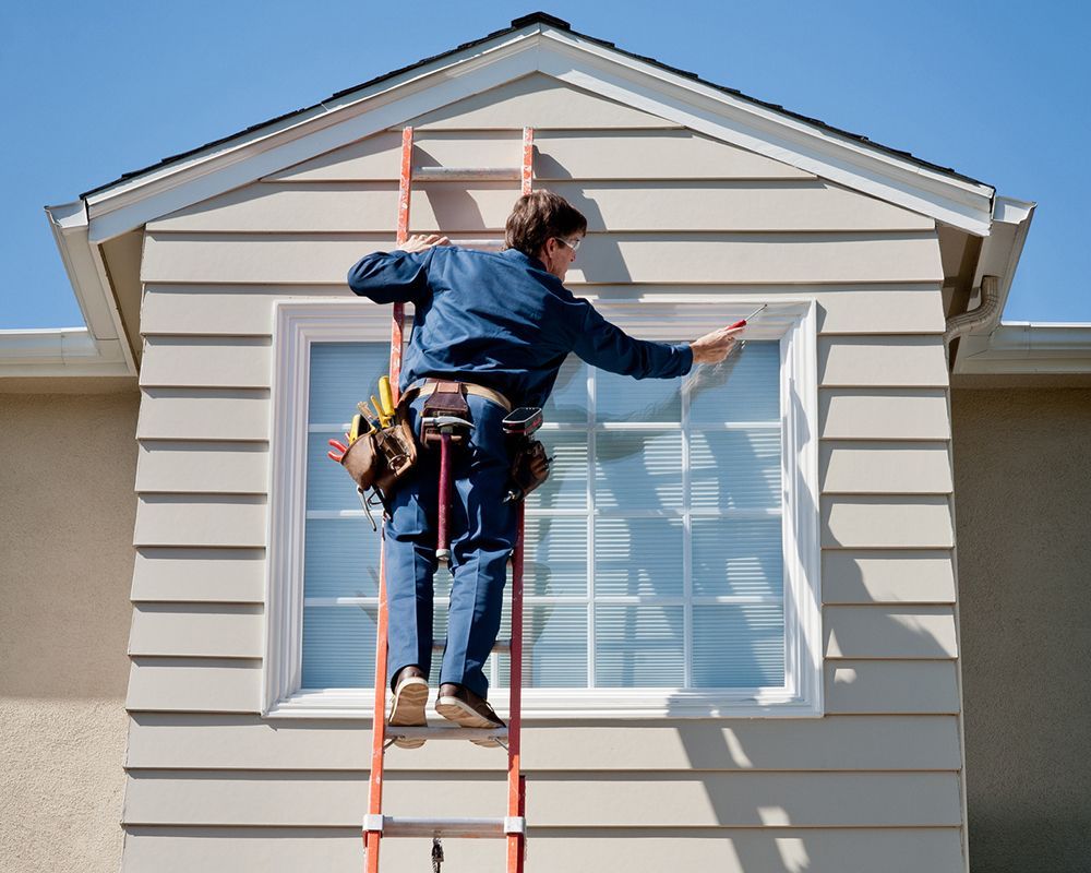 A siding contractor from Bon Air Exteriors is inspecting a house for siding repair in Richmond, VA.