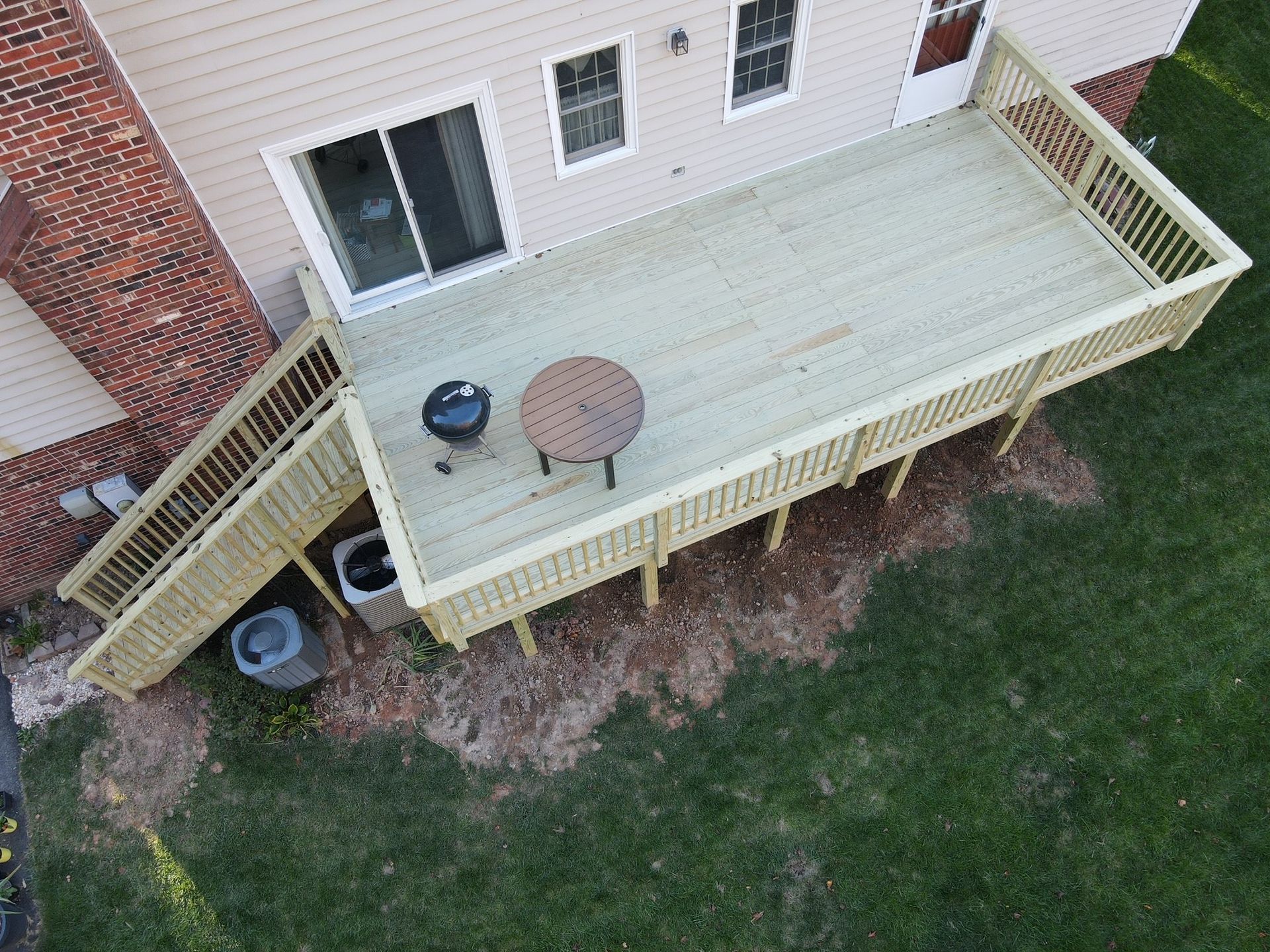 An aerial view of a wooden deck in front of a house.