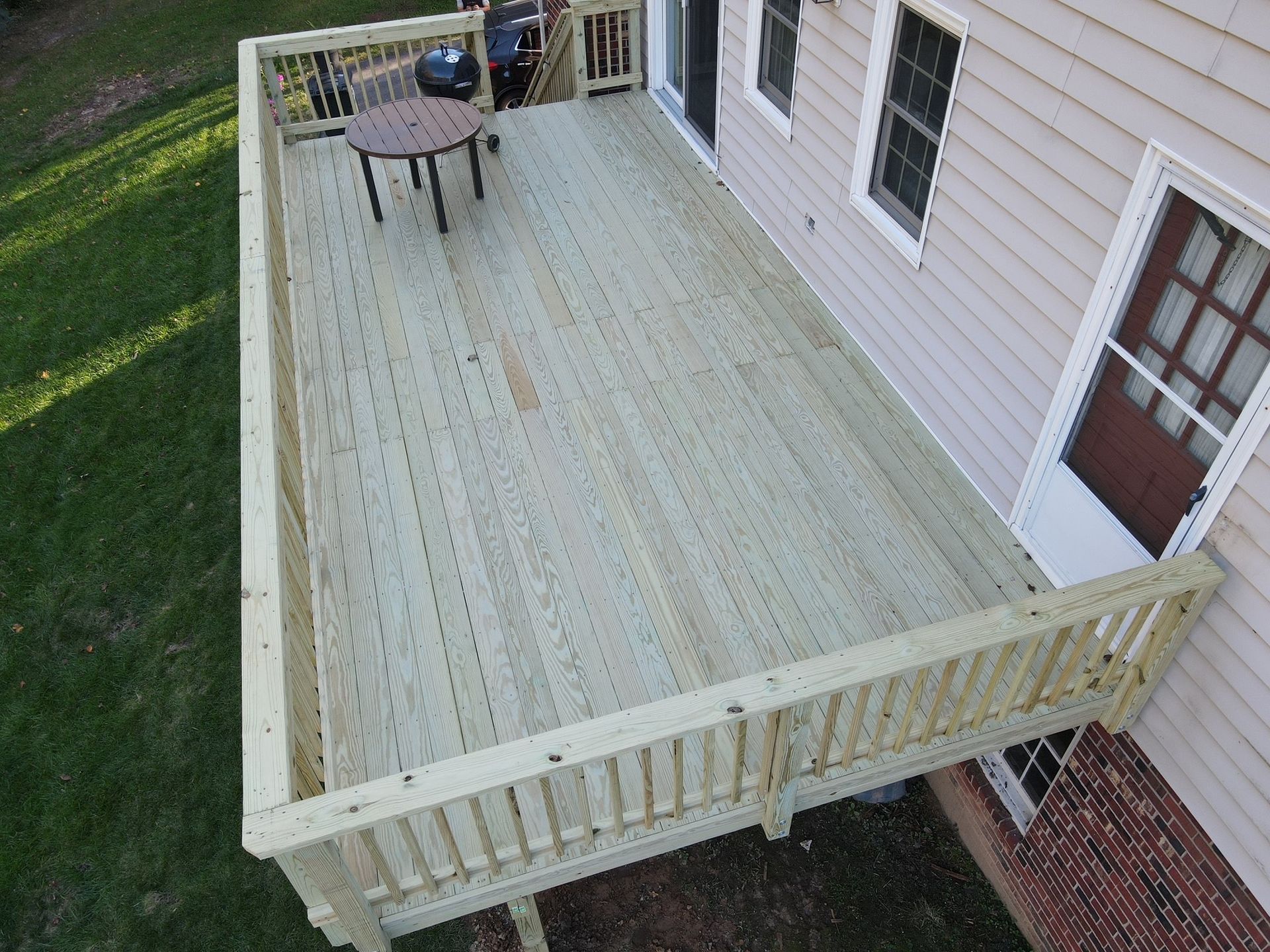 An aerial view of a wooden deck with a table and chairs on it.