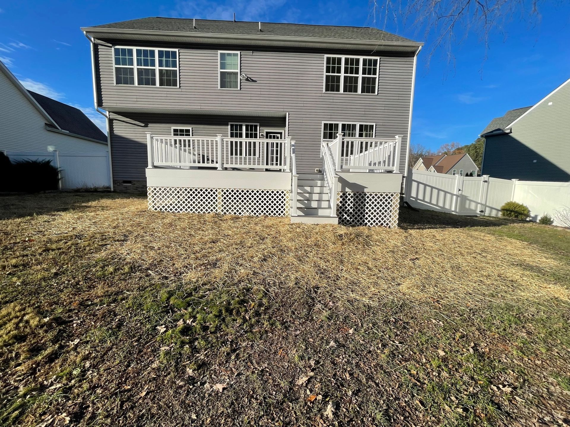 The back of a house with a large deck and stairs.