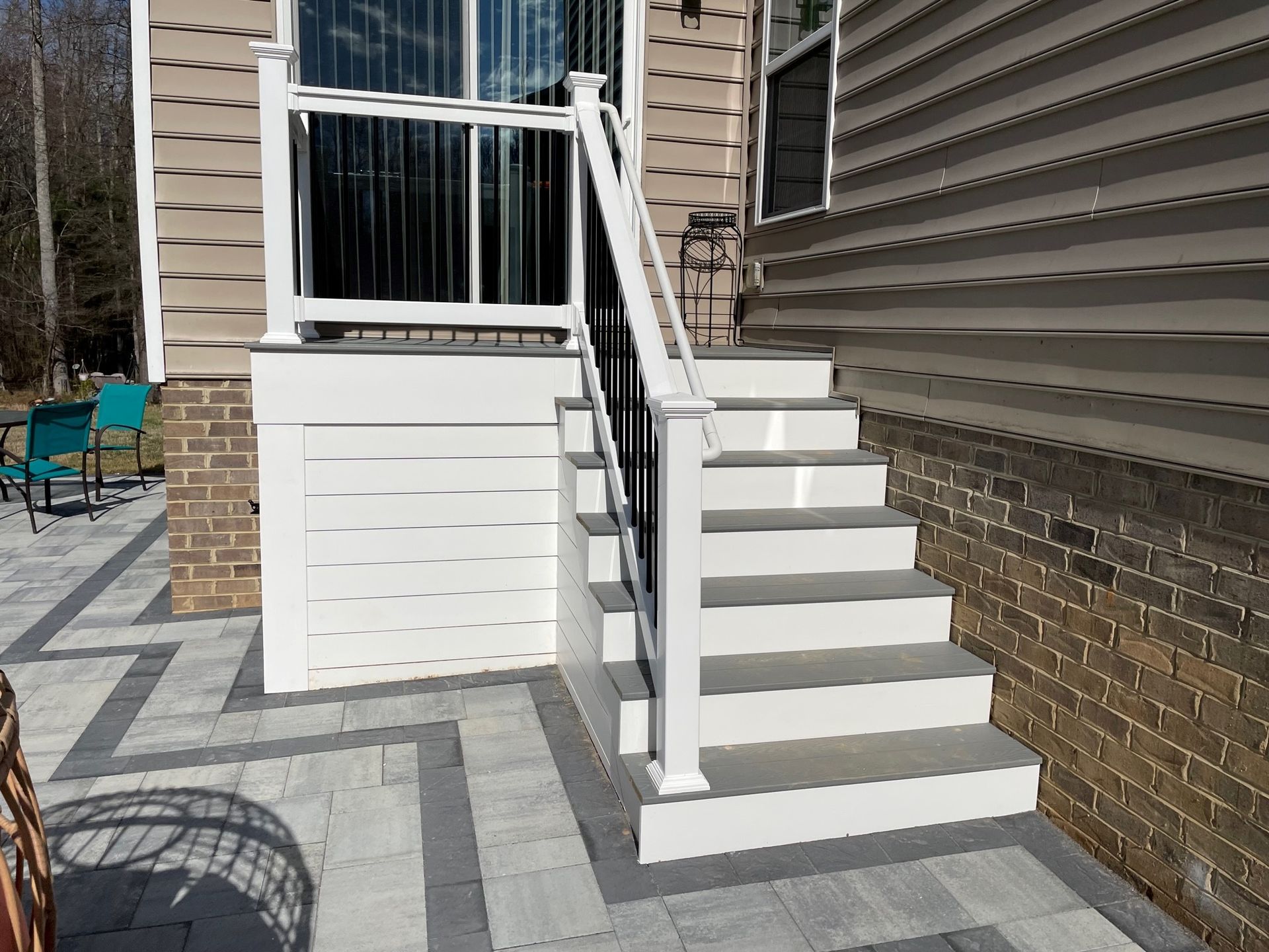 A set of stairs leading up to a patio next to a house.