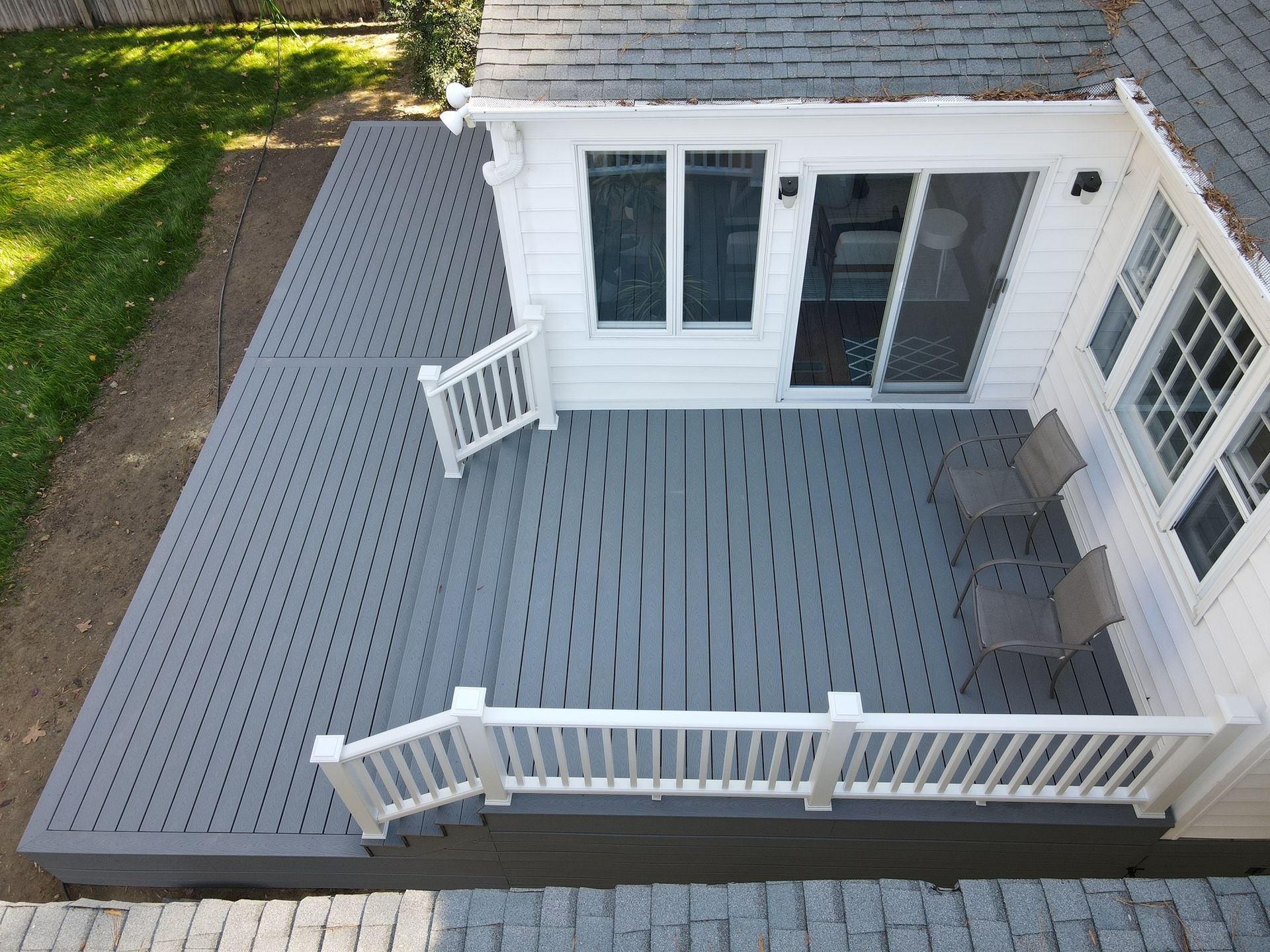 An aerial view of a white house with a gray deck
