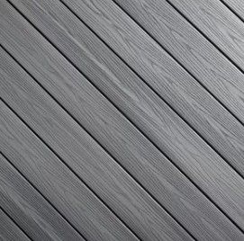 A close up of a gray wooden deck with a diagonal pattern.
