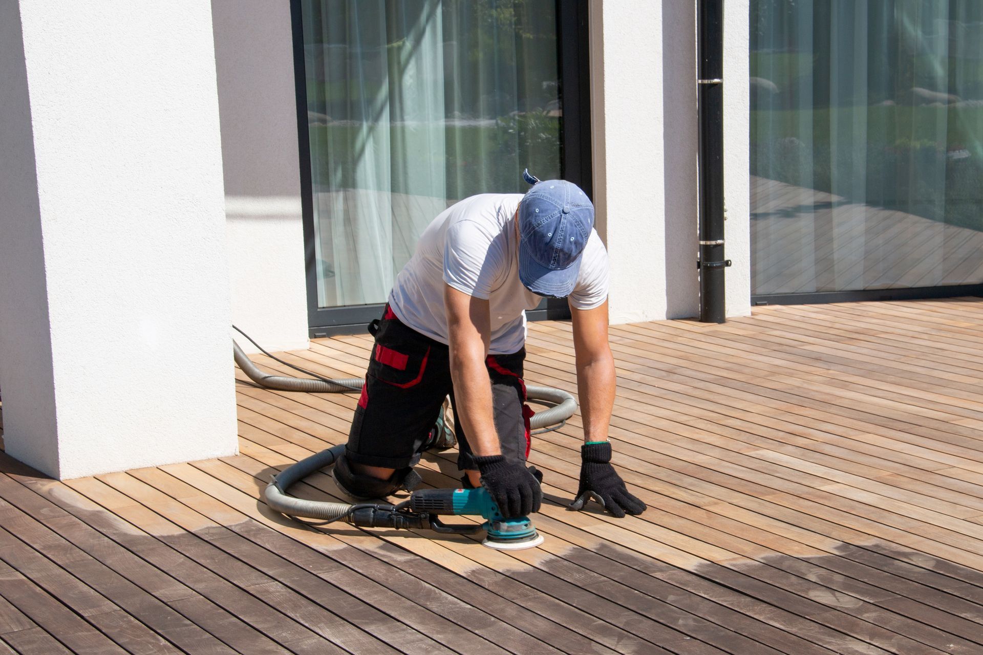 A residential deck builder sanding a wooden deck. A residential deck builder sanding a wooden deck.