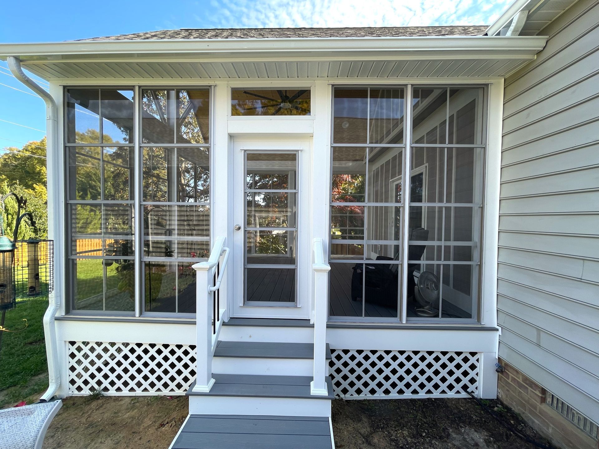 A white house with a screened in porch and stairs