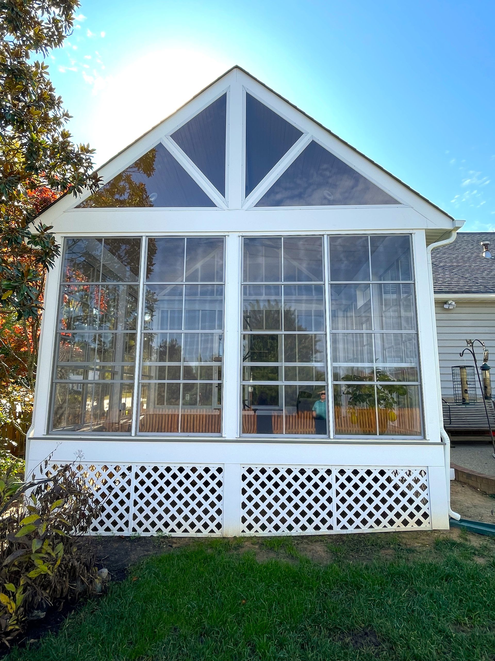 A white house with a screened in porch with lots of windows