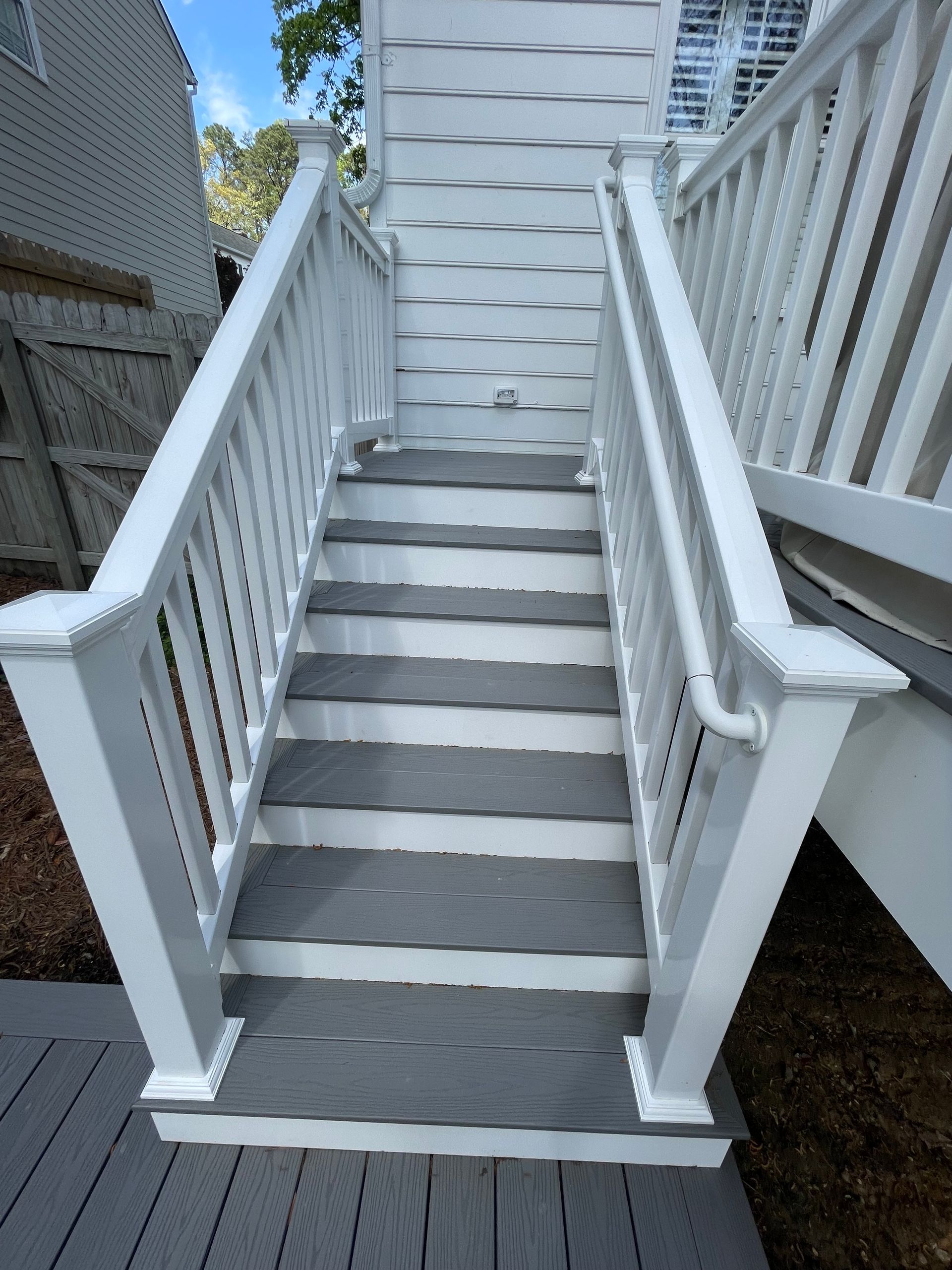 Gray steps with white railing leading upwards.