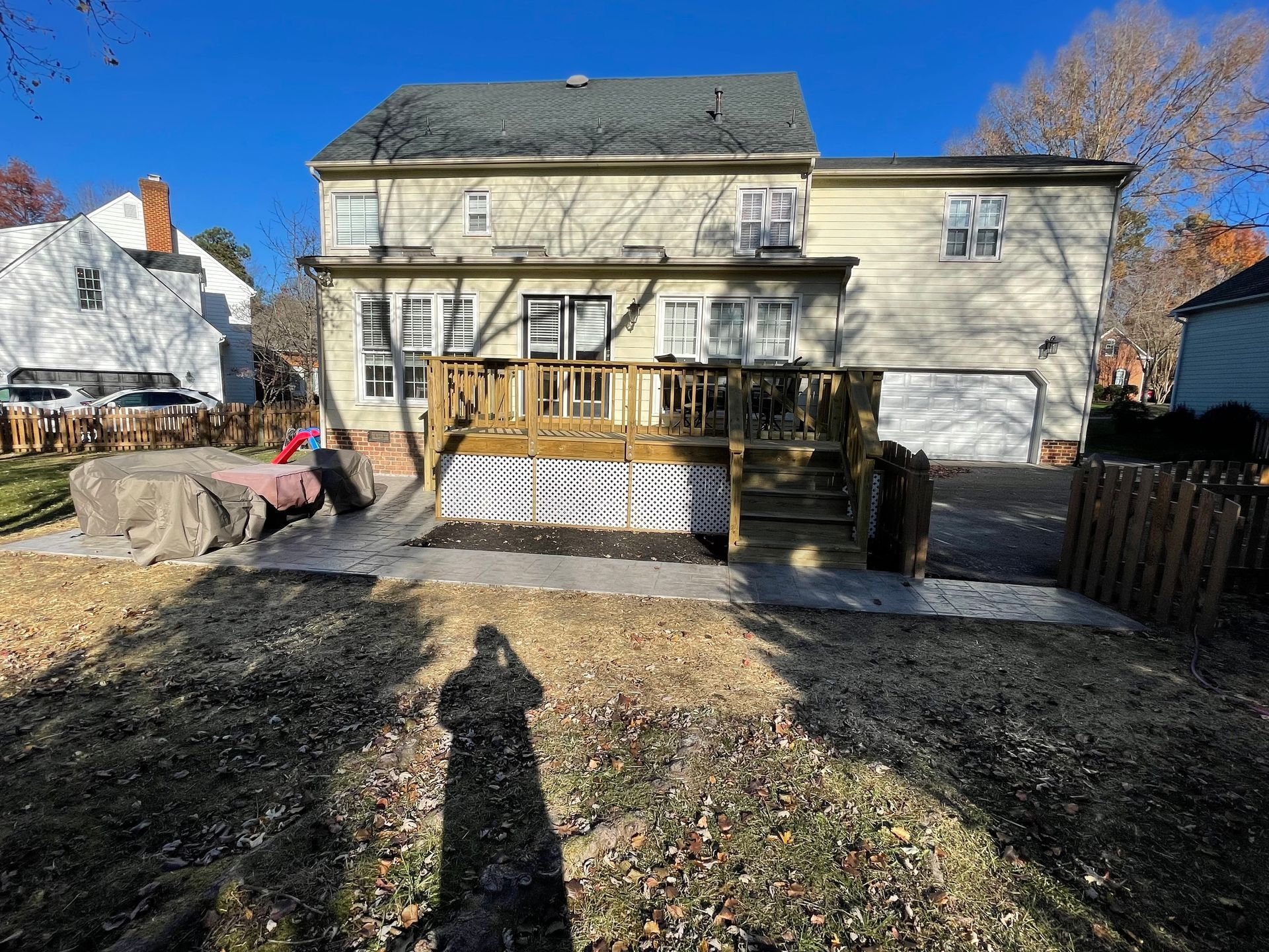 A large white house with a large deck in the backyard.