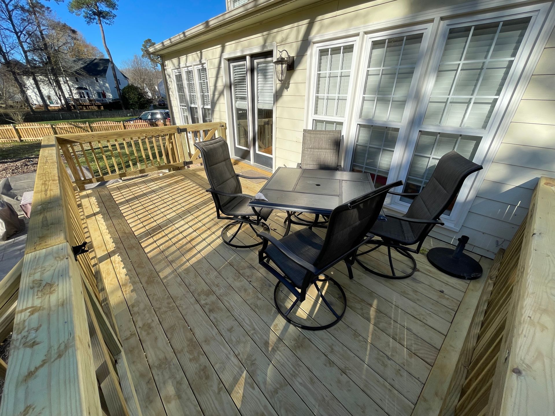 A wooden deck with a table and chairs on it.