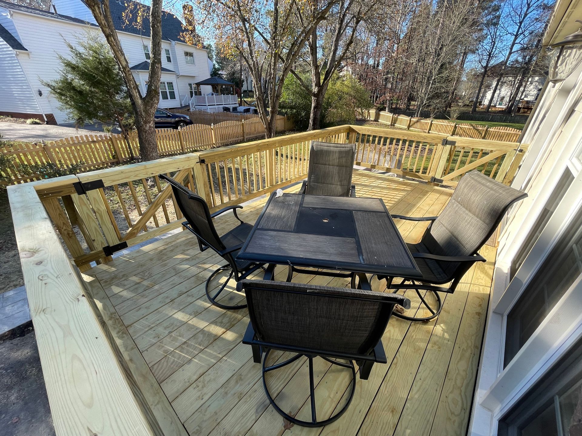 A wooden deck with a table and chairs on it.