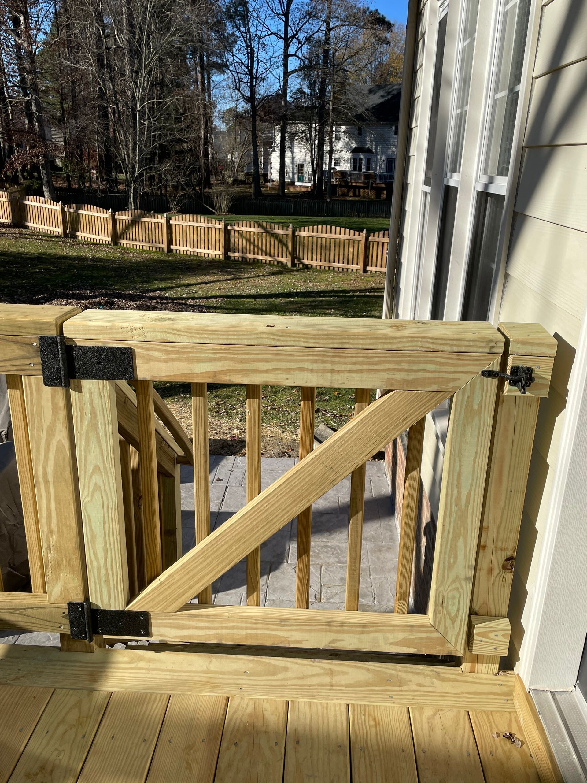 A wooden gate is sitting on top of a wooden deck.