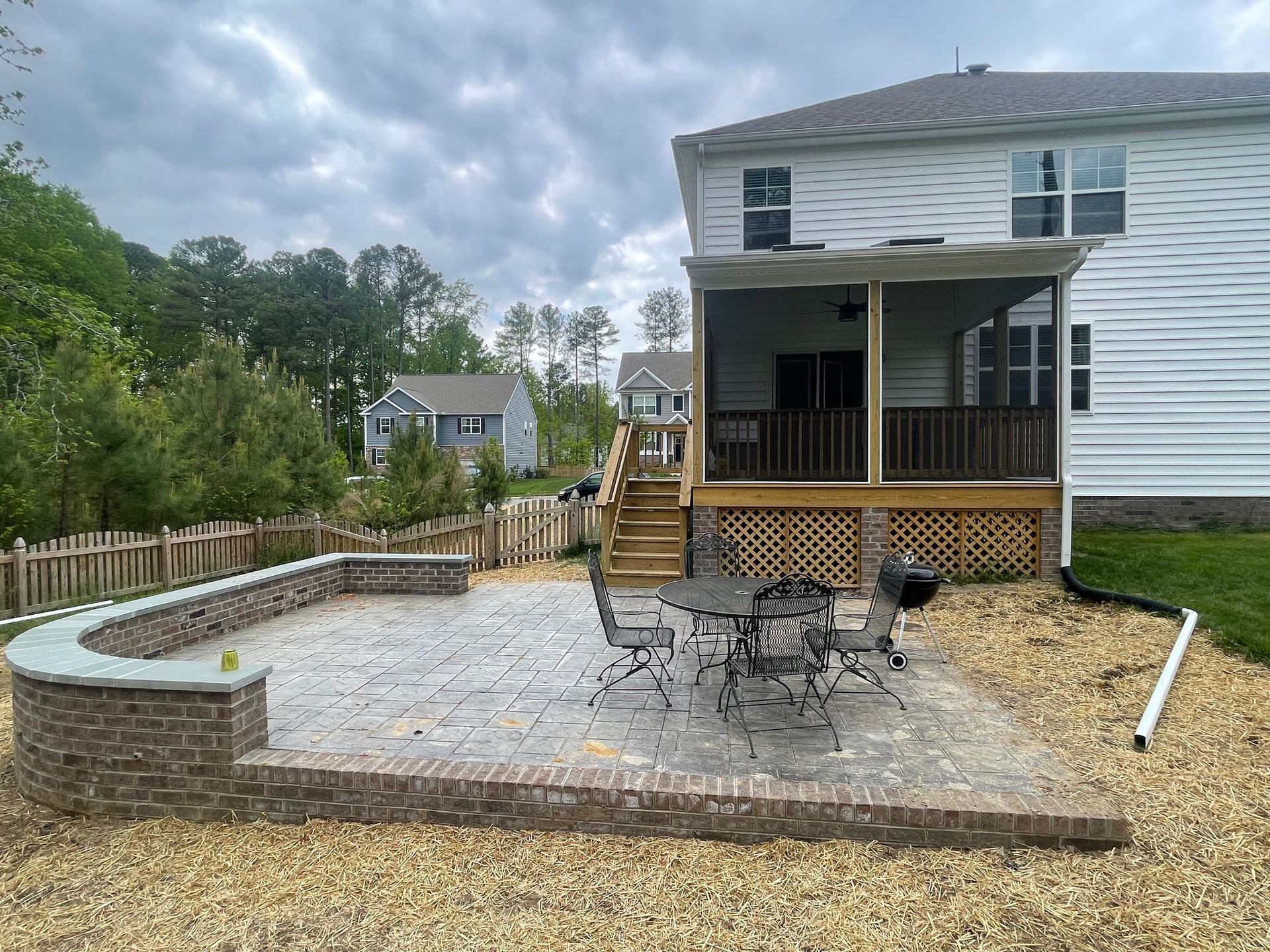 A patio with a table and chairs in front of a house.