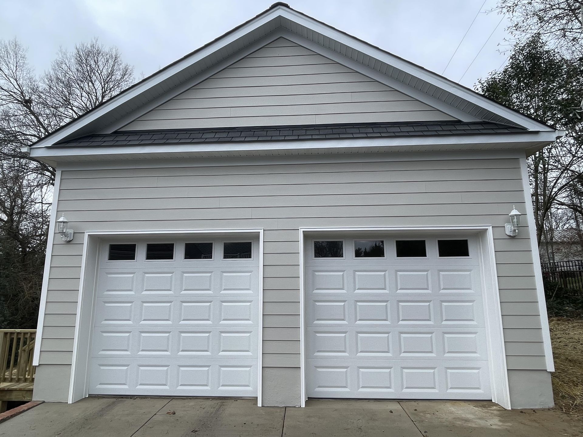 A garage with two white garage doors and a roof