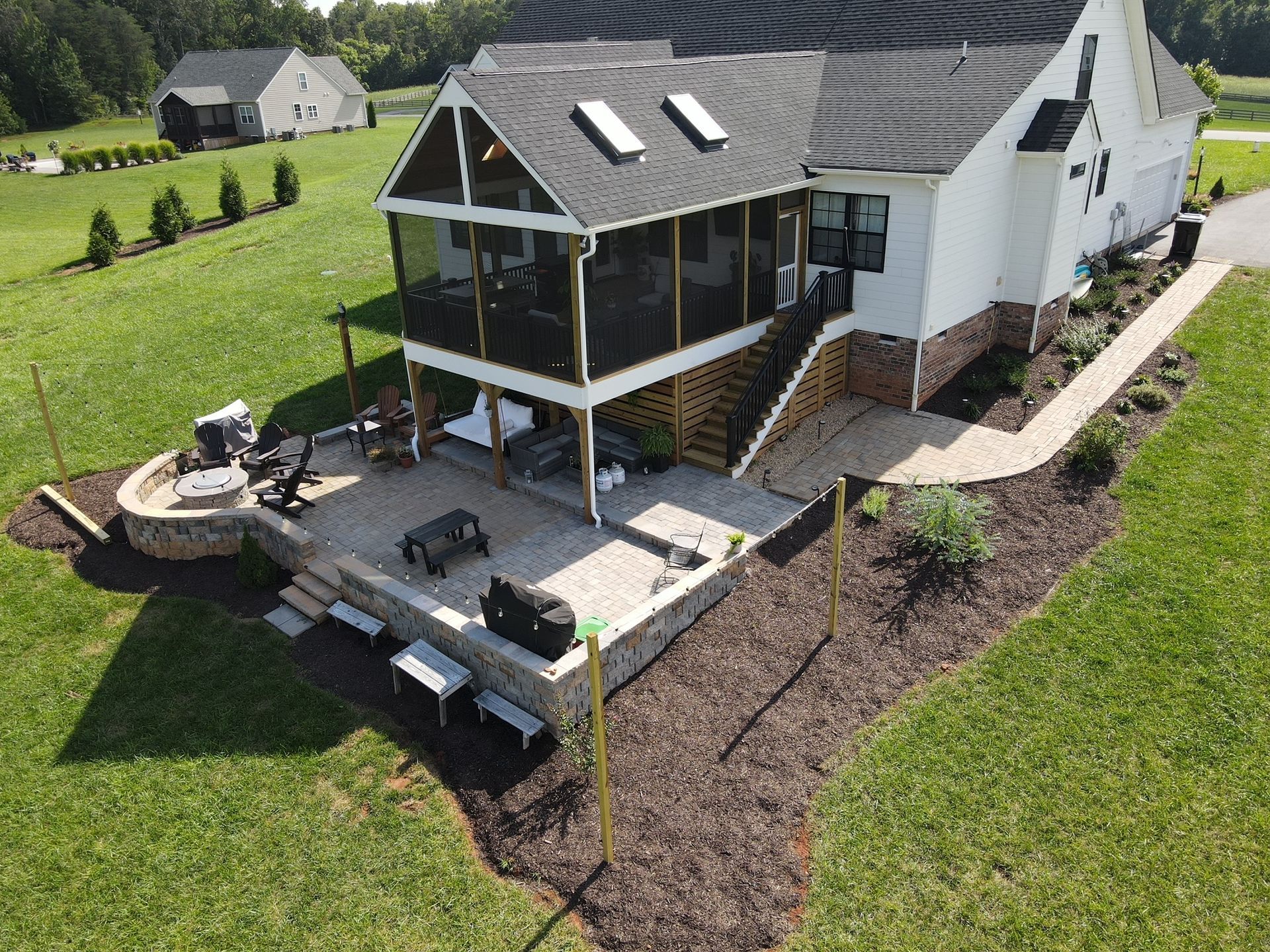 An aerial view of a house with a screened in porch and patio.