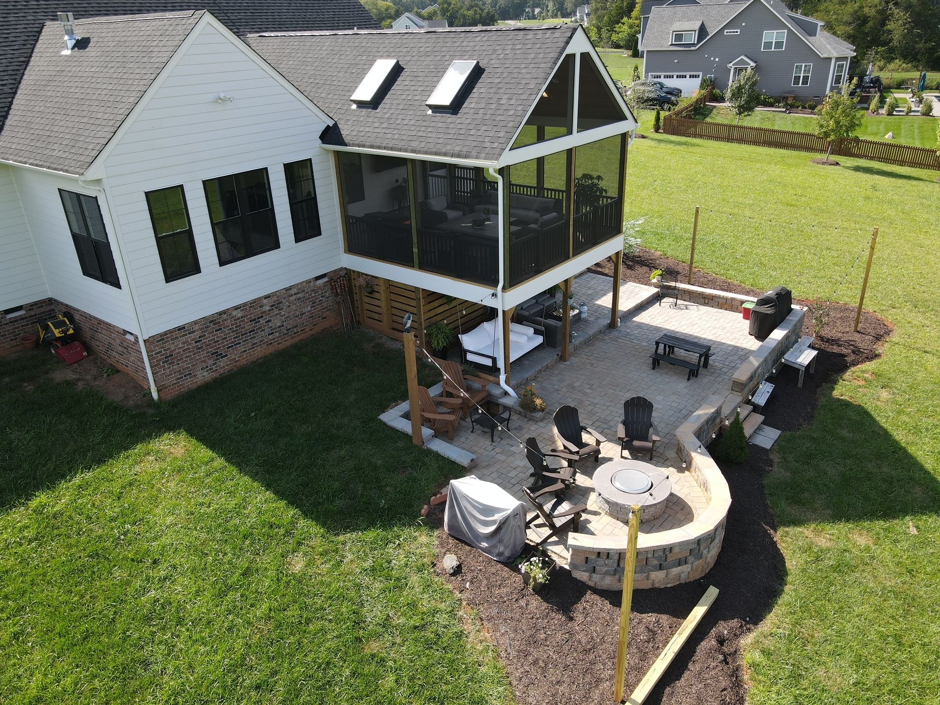 An aerial view of a house with a screened in porch and patio.