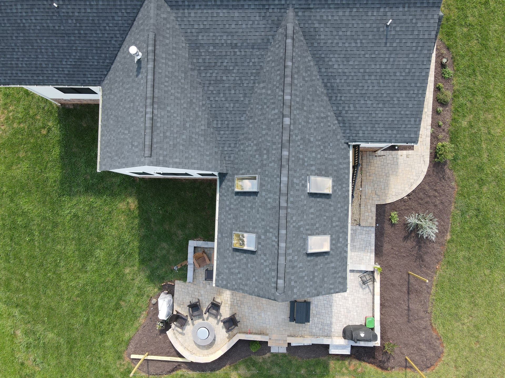 An aerial view of a house with a patio and a fire pit.