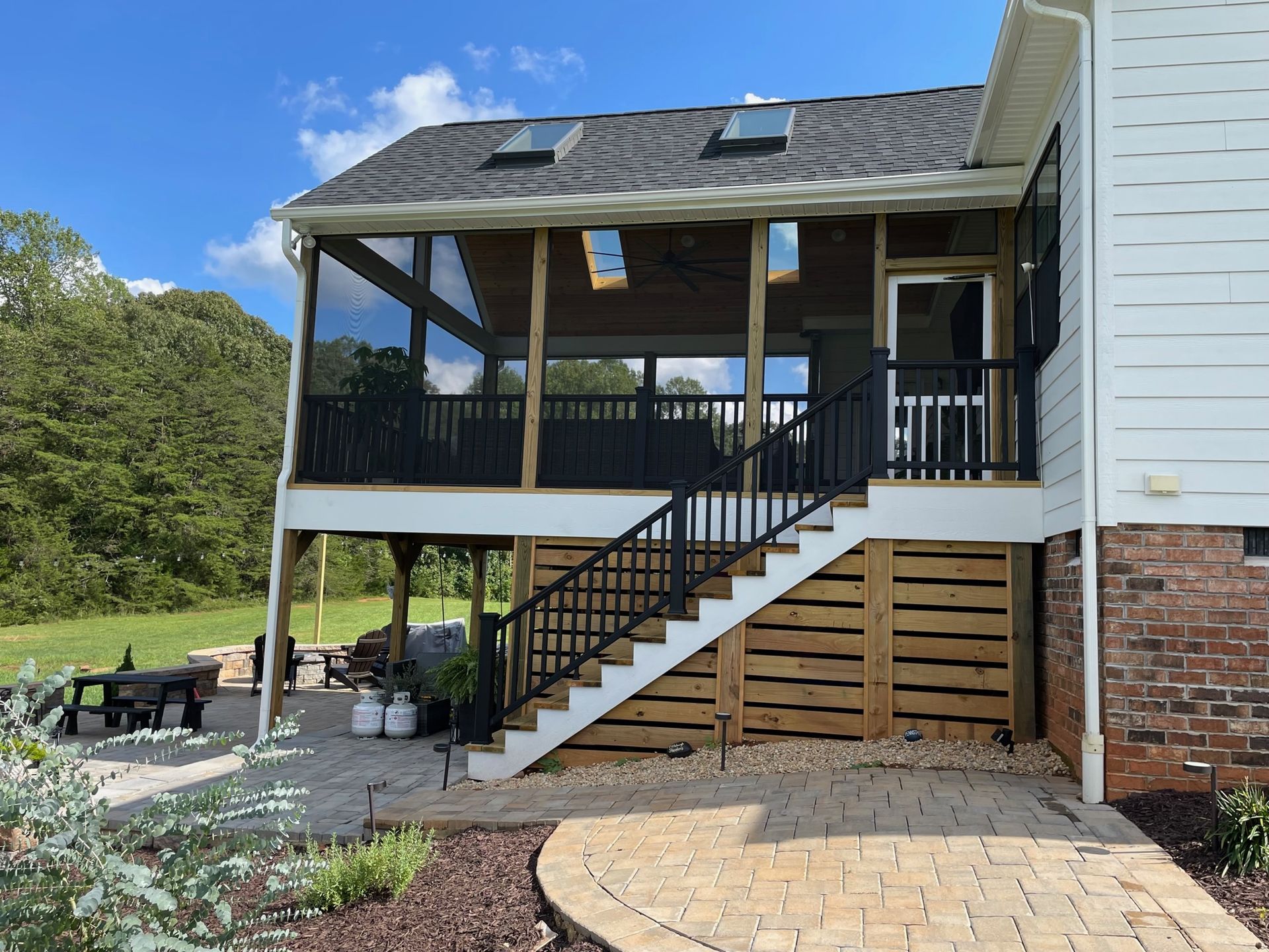 A house with a screened in porch and stairs leading up to it.