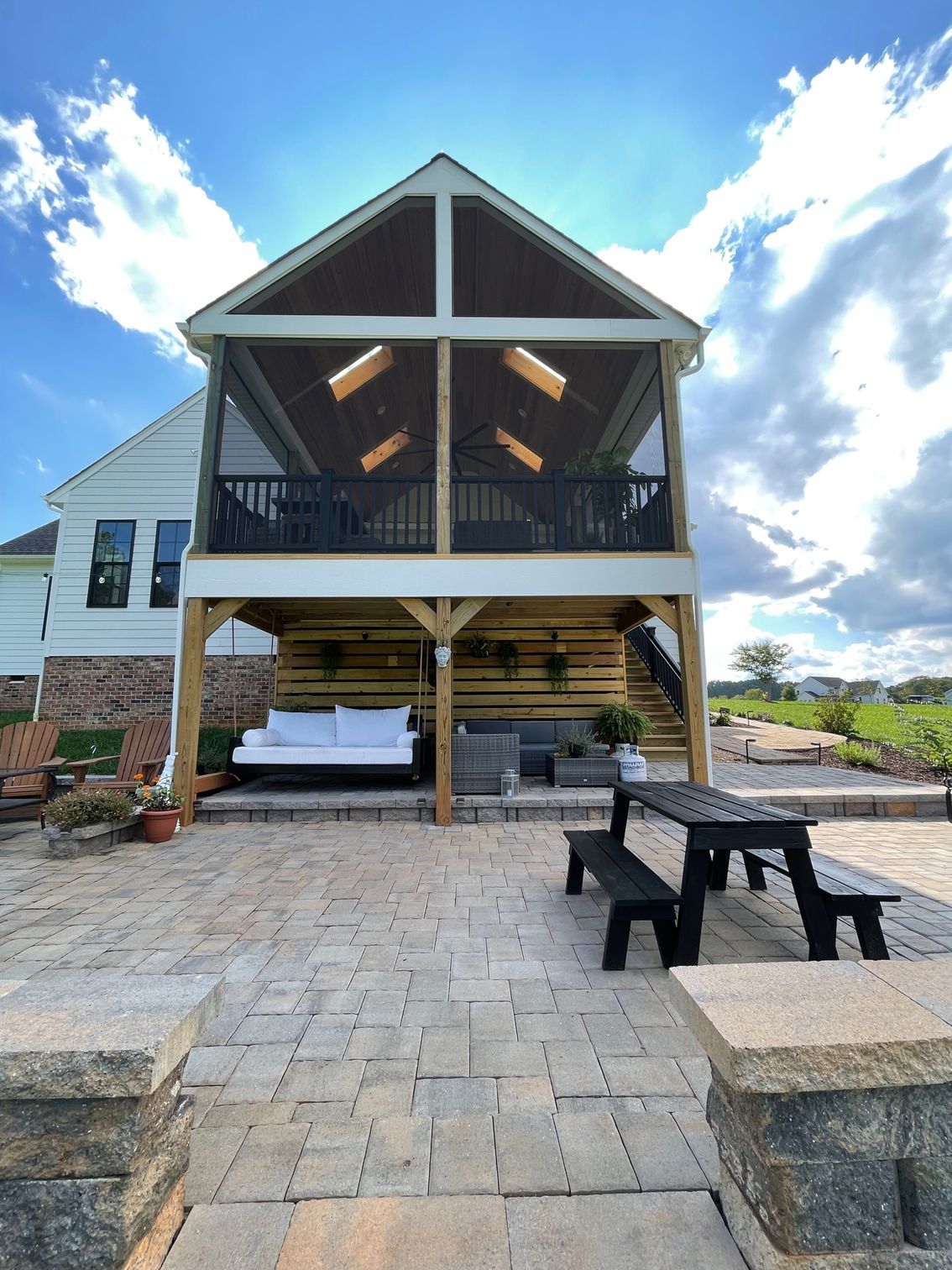 A house with a screened in porch and a picnic table