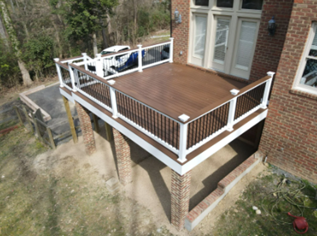 Wooden deck with railing and door, built by a deck-building company for cozy outdoor space.