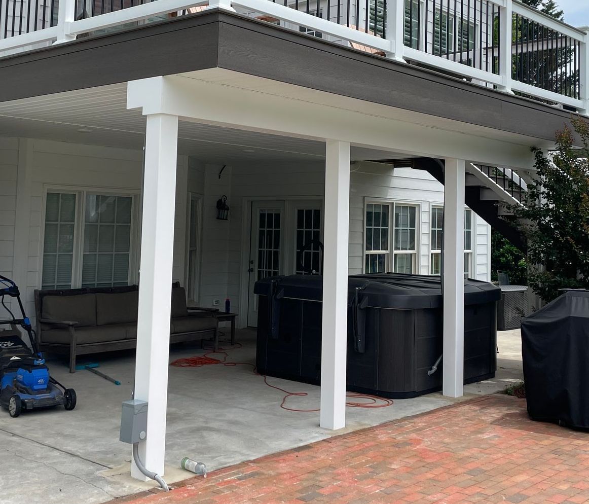 A patio with a hot tub and a lawn mower on it