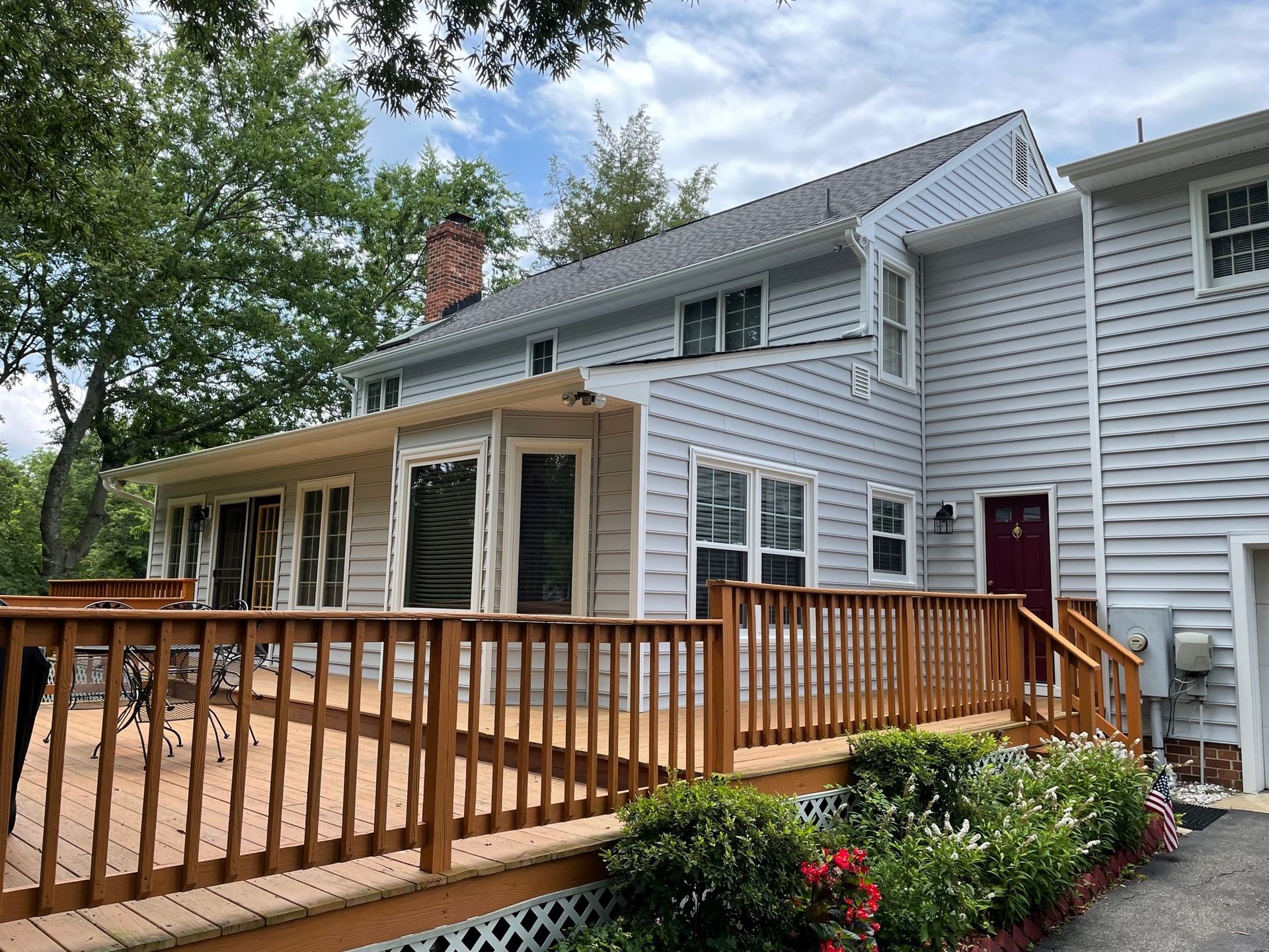 A large white house with a wooden deck in front of it.