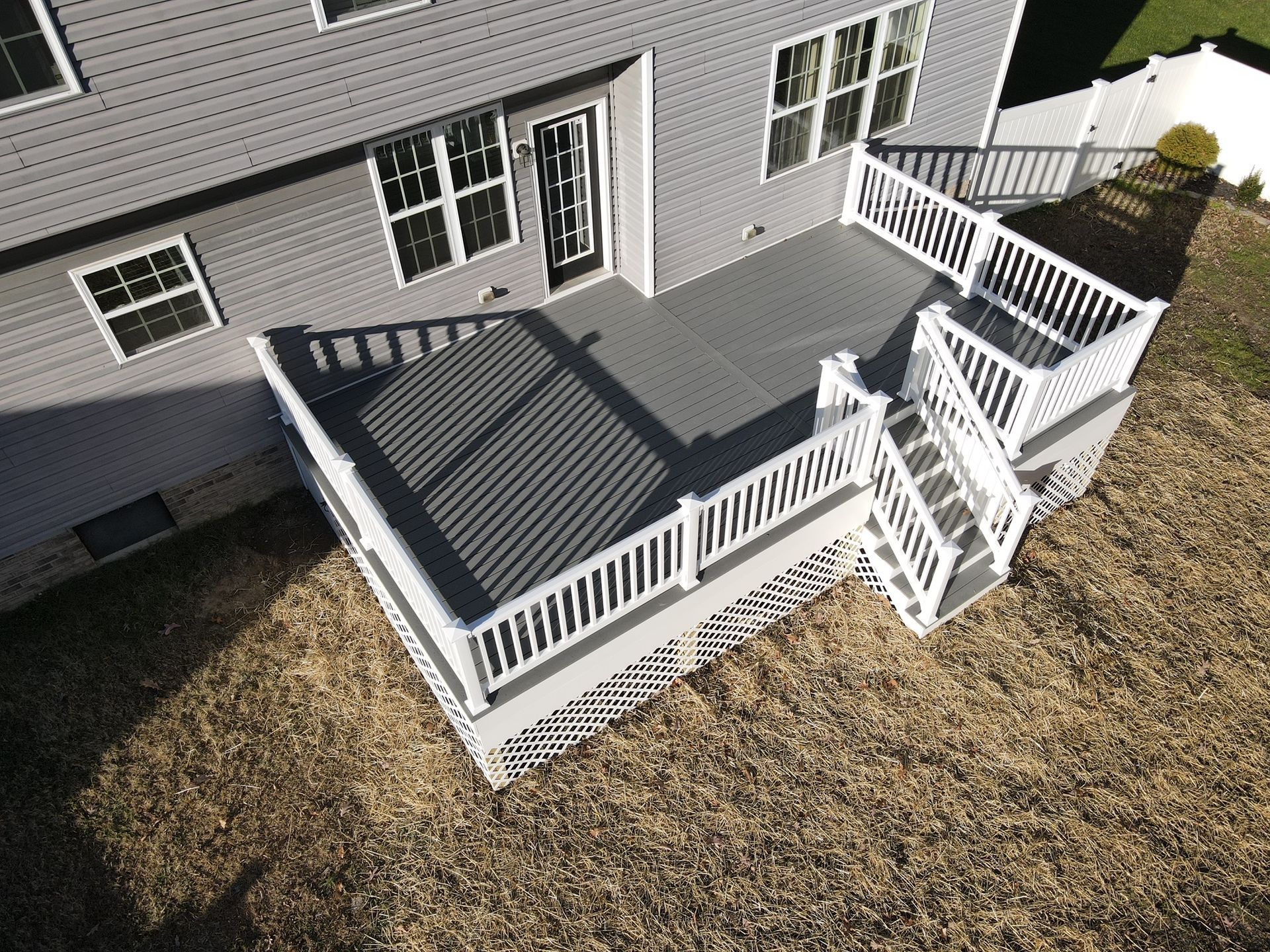 An aerial view of a house with a large deck and stairs.