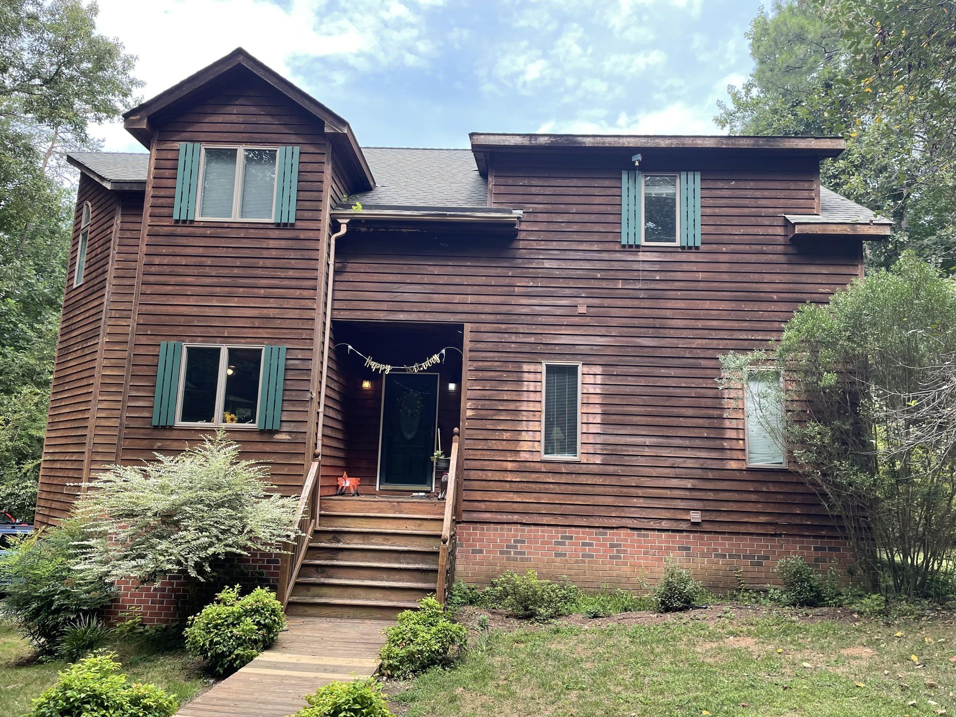 A large wooden house with blue shutters on the windows